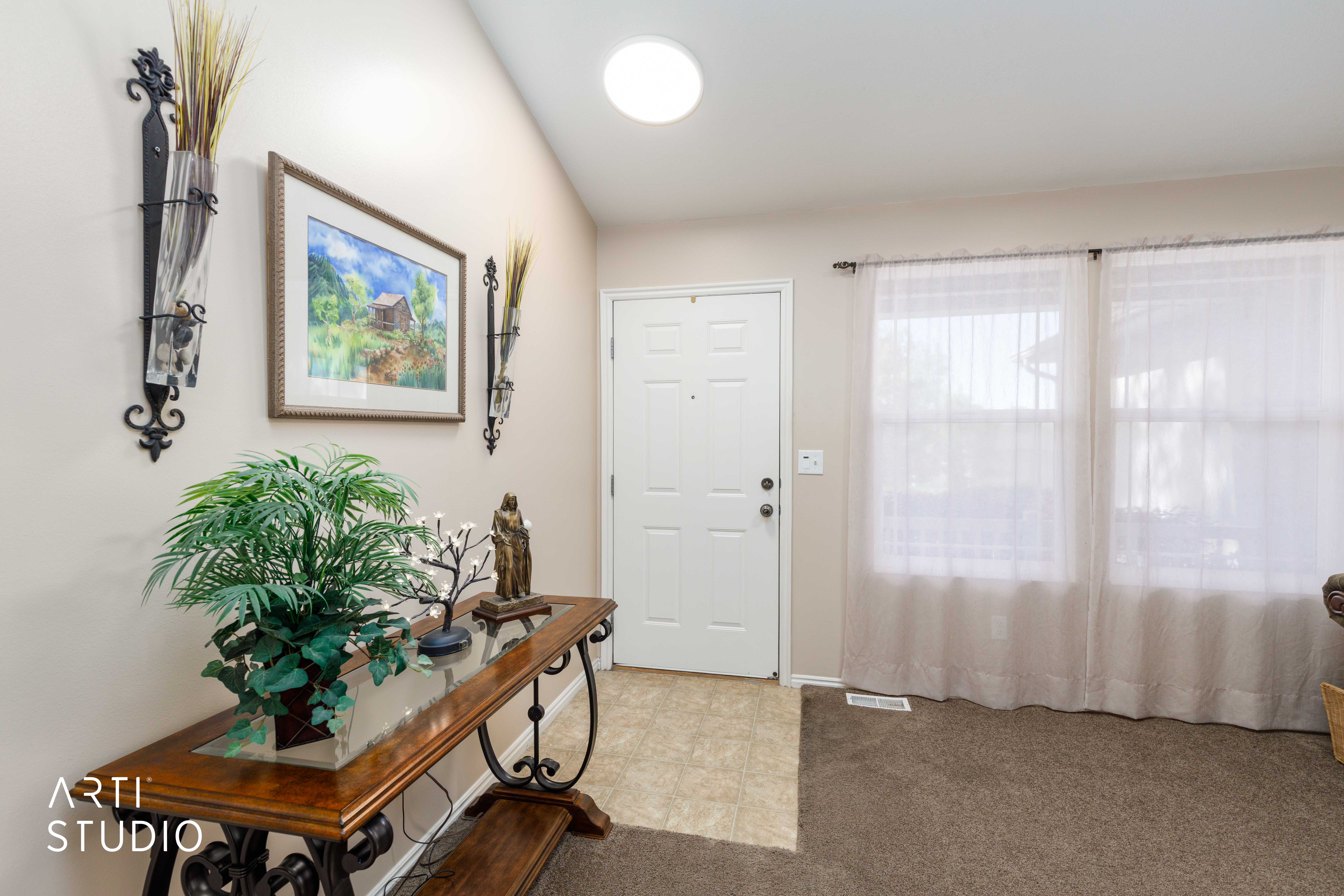Entryway featuring a solid white door, dual large windows, and a circular overhead light