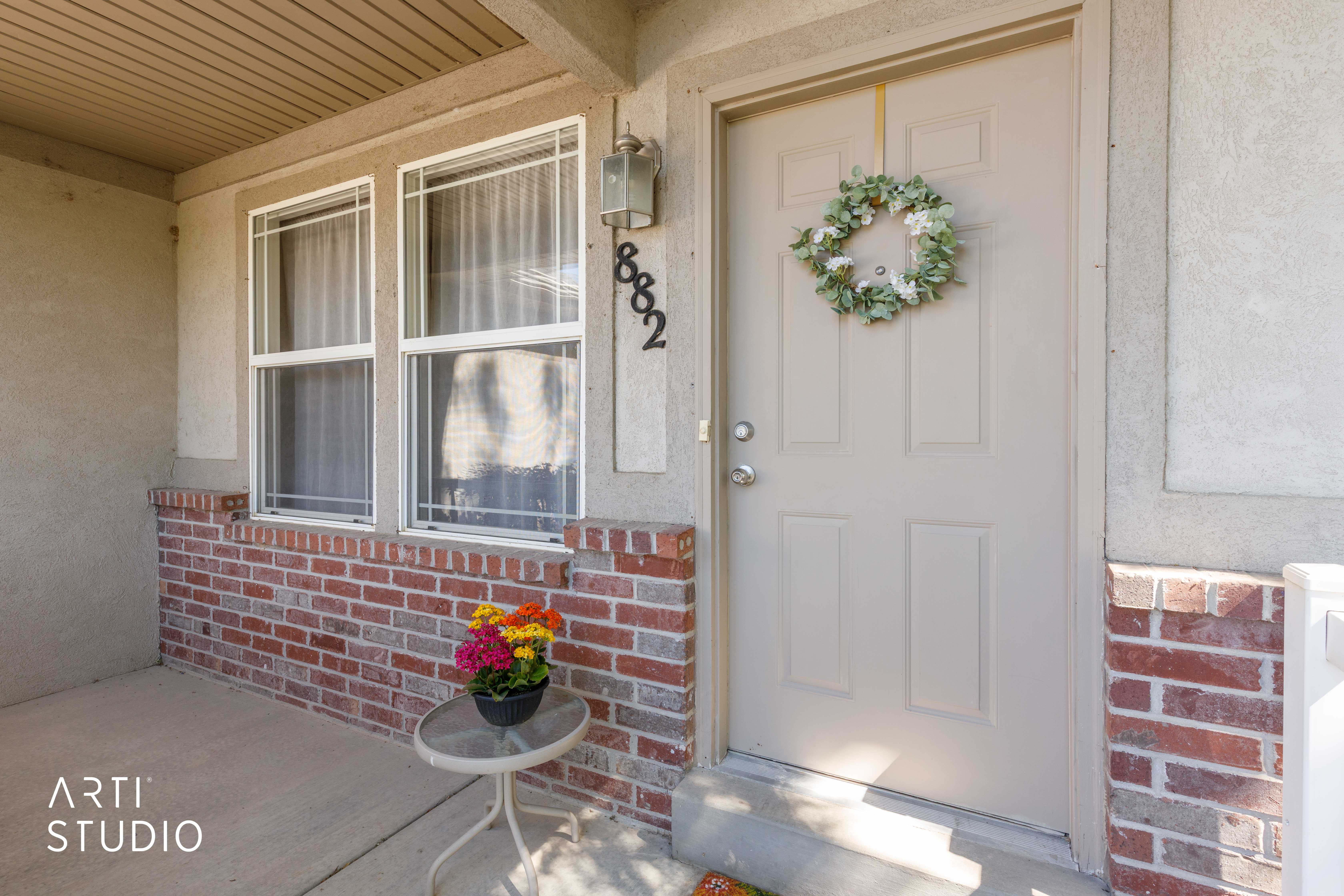 Inviting front entry featuring a paneled door, brick wainscoting, and an overhead porch light