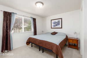 Bright room featuring a window with horizontal blinds, neutral wall paint, and light-colored carpeting