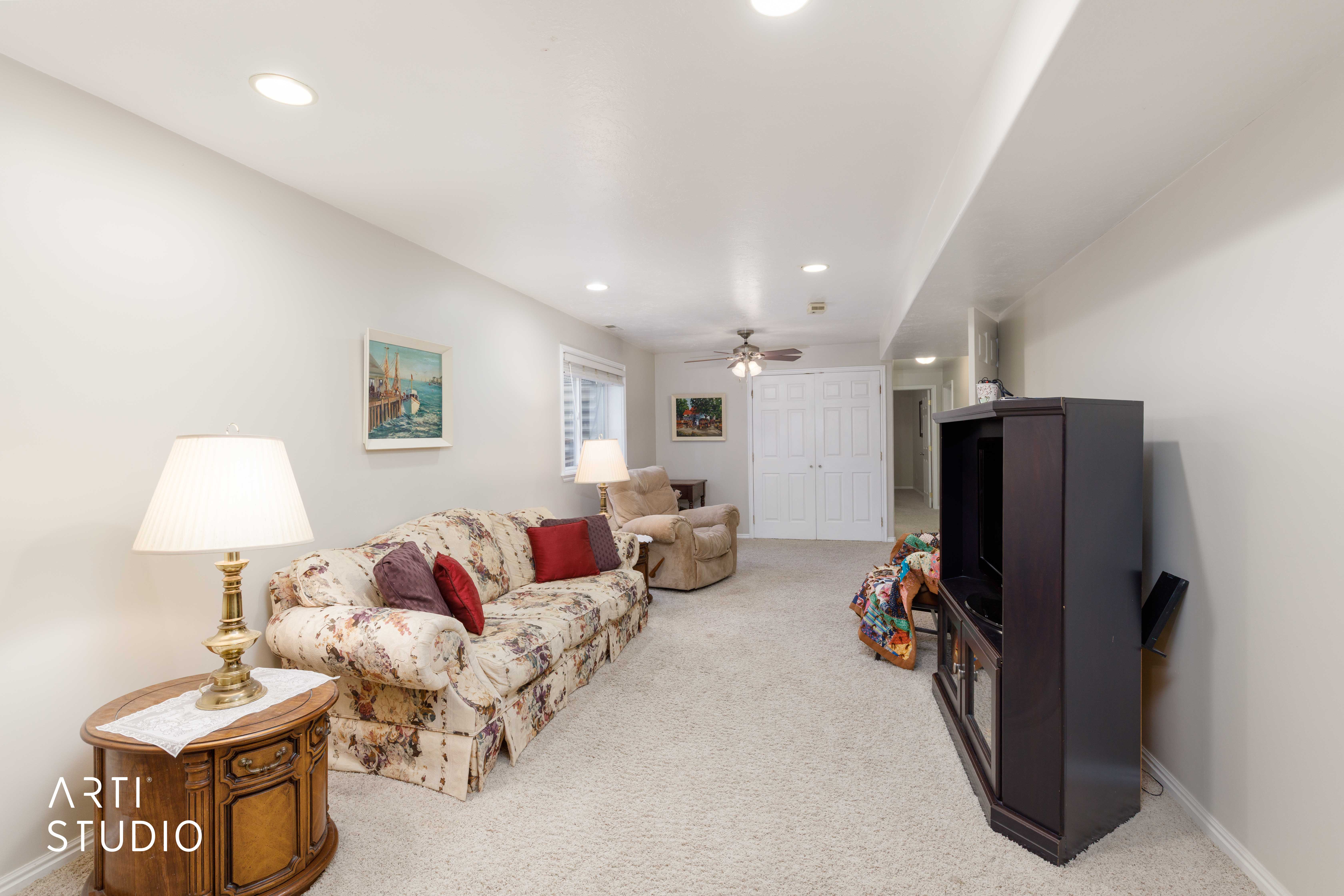 Spacious room featuring light-toned walls, recessed lighting, and soft carpeting