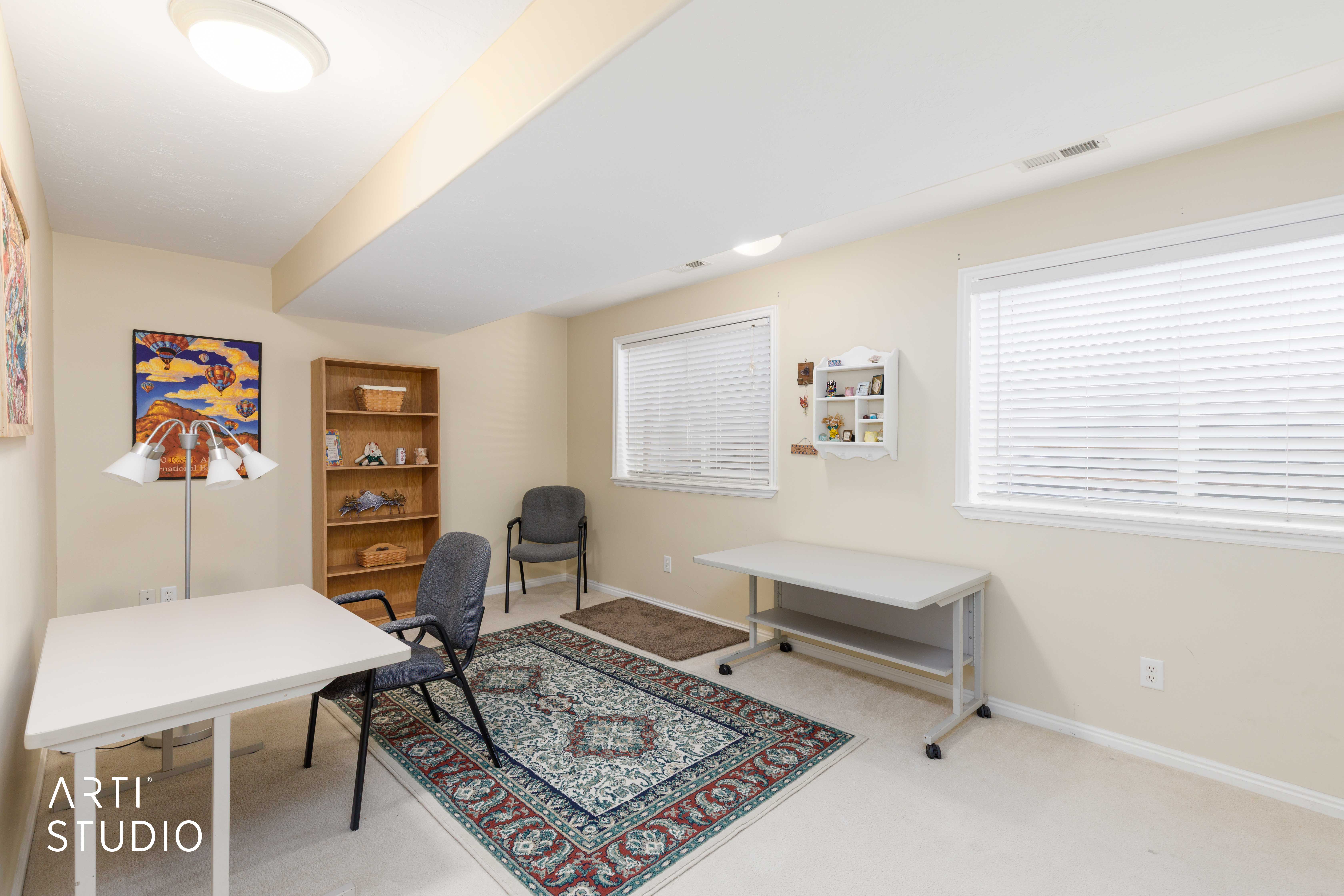 Finished room featuring two windows with horizontal blinds, neutral wall paint, and a built-in wooden bookshelf