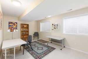 Finished room featuring two windows with horizontal blinds, neutral wall paint, and a built-in wooden bookshelf