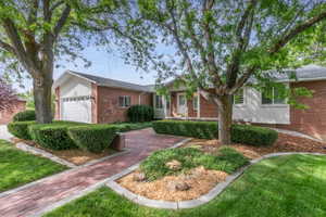 Inviting porch area complemented by a red brick paver pathway.