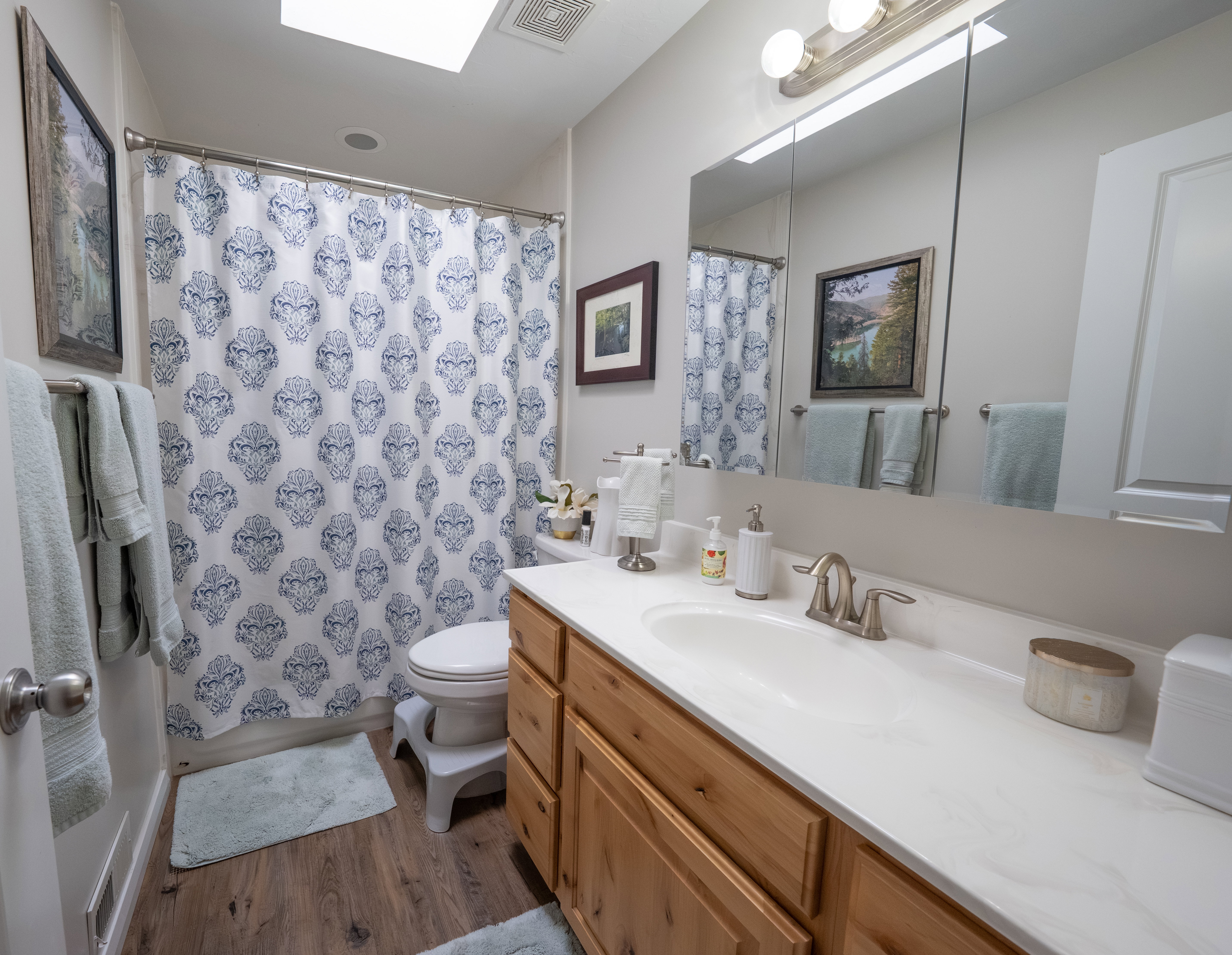 Bathroom featuring a single vanity with wood cabinetry, a white countertop, and an integrated sink