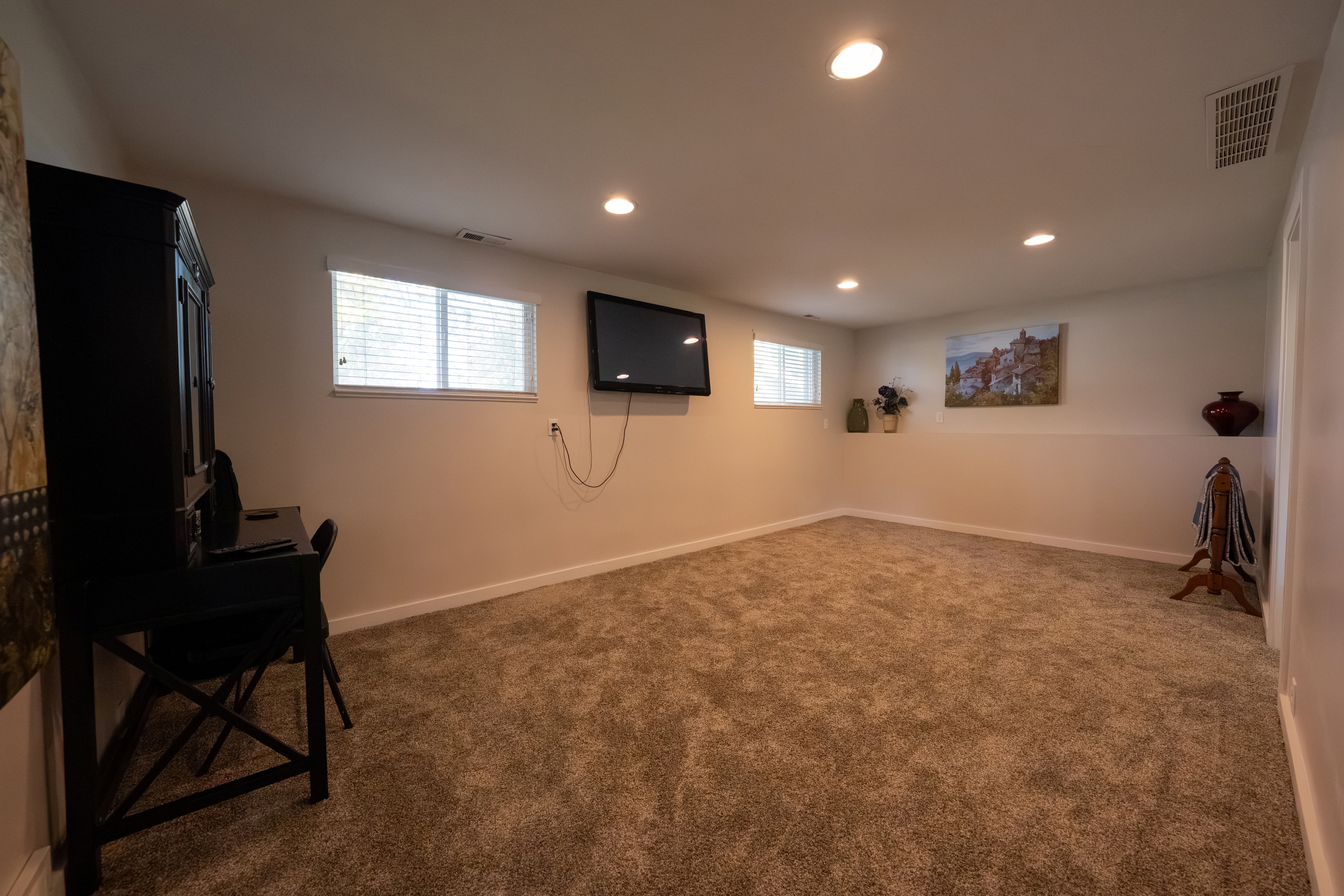Carpeted room featuring recessed lighting, light-toned walls with a chair rail, and multiple windows with blinds