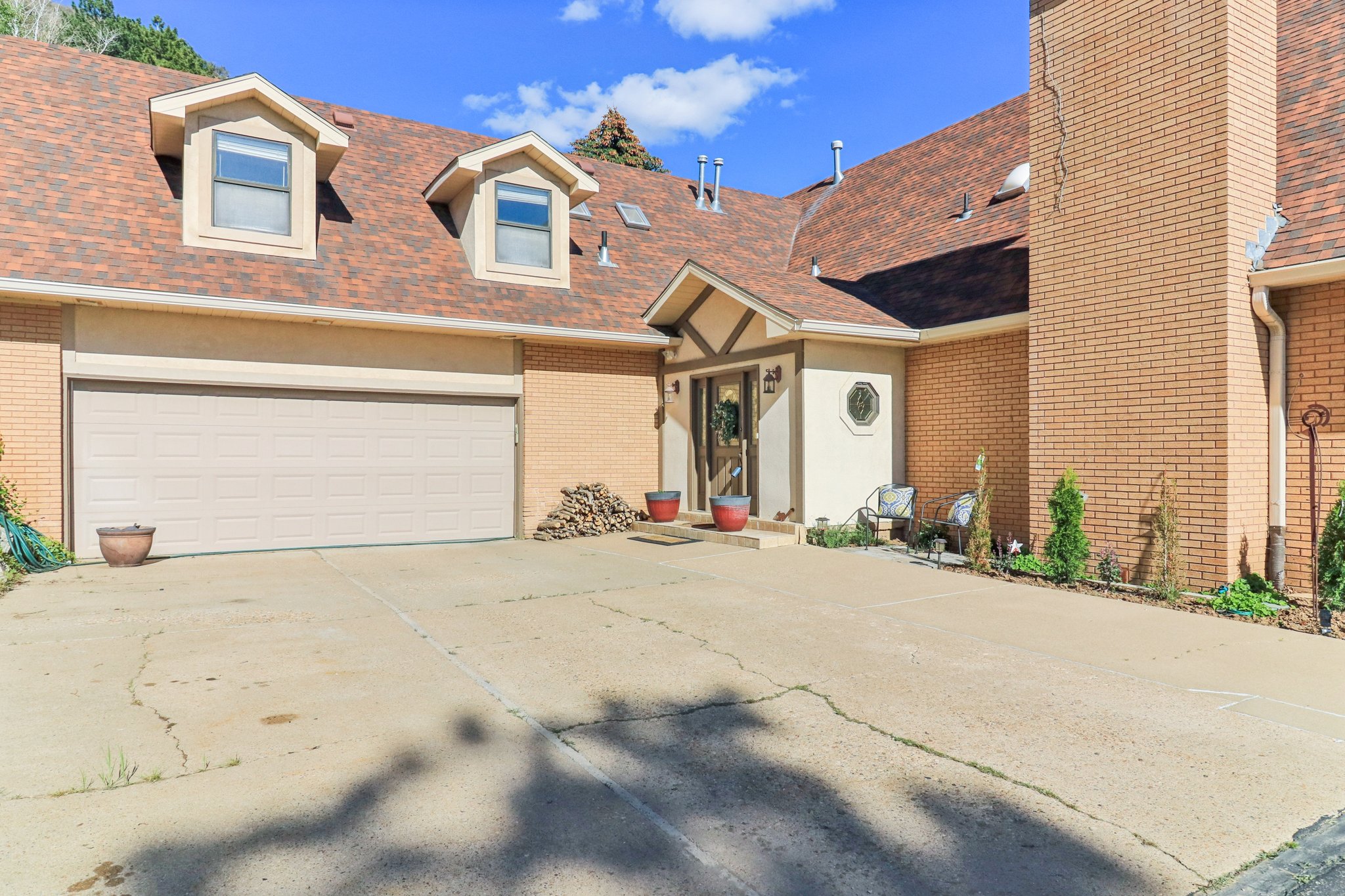 Brick exterior with a multi-gabled roofline and two dormer windows