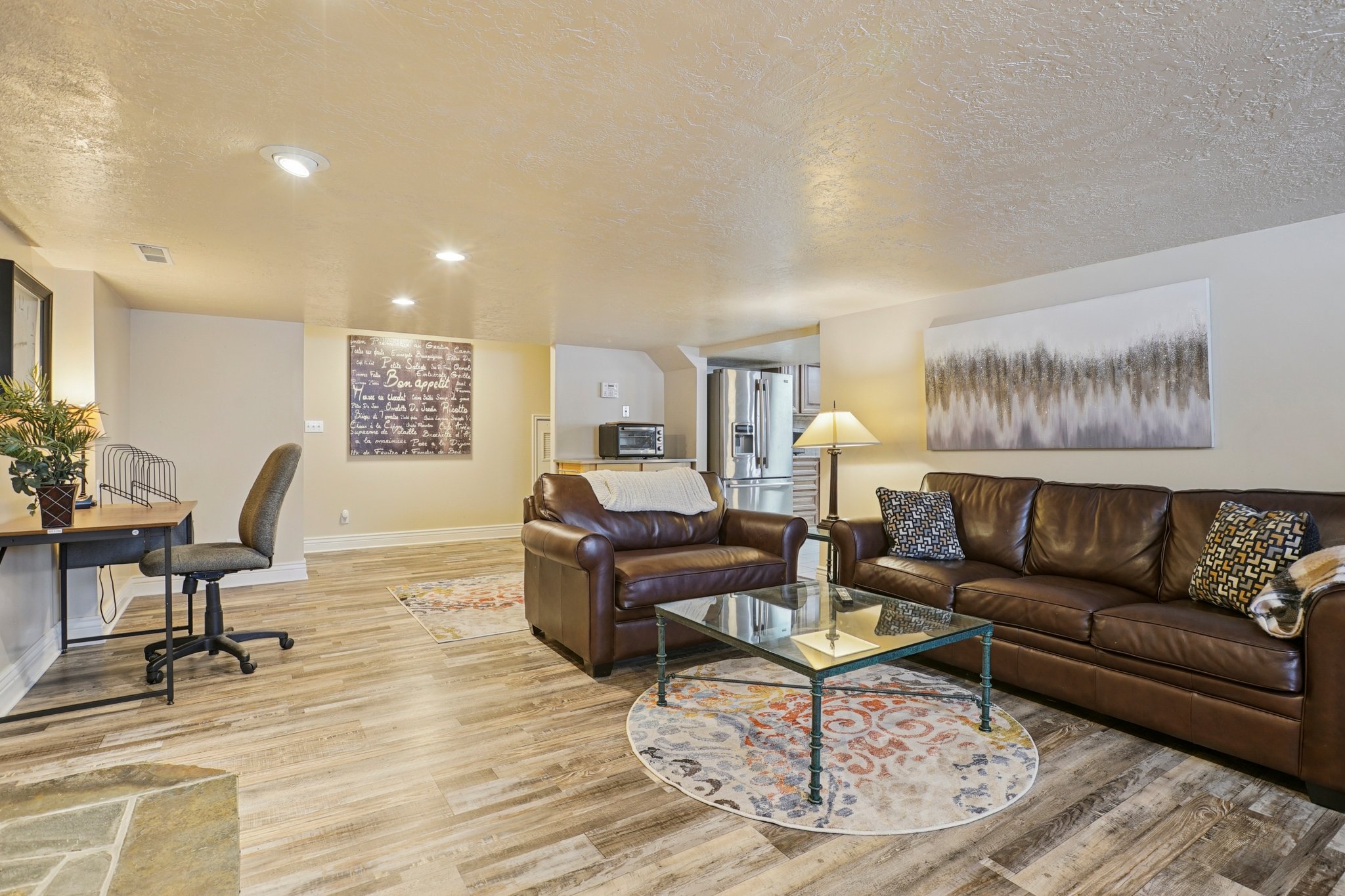 Spacious living area featuring wood-finish flooring, recessed lighting, and a neutral color palette