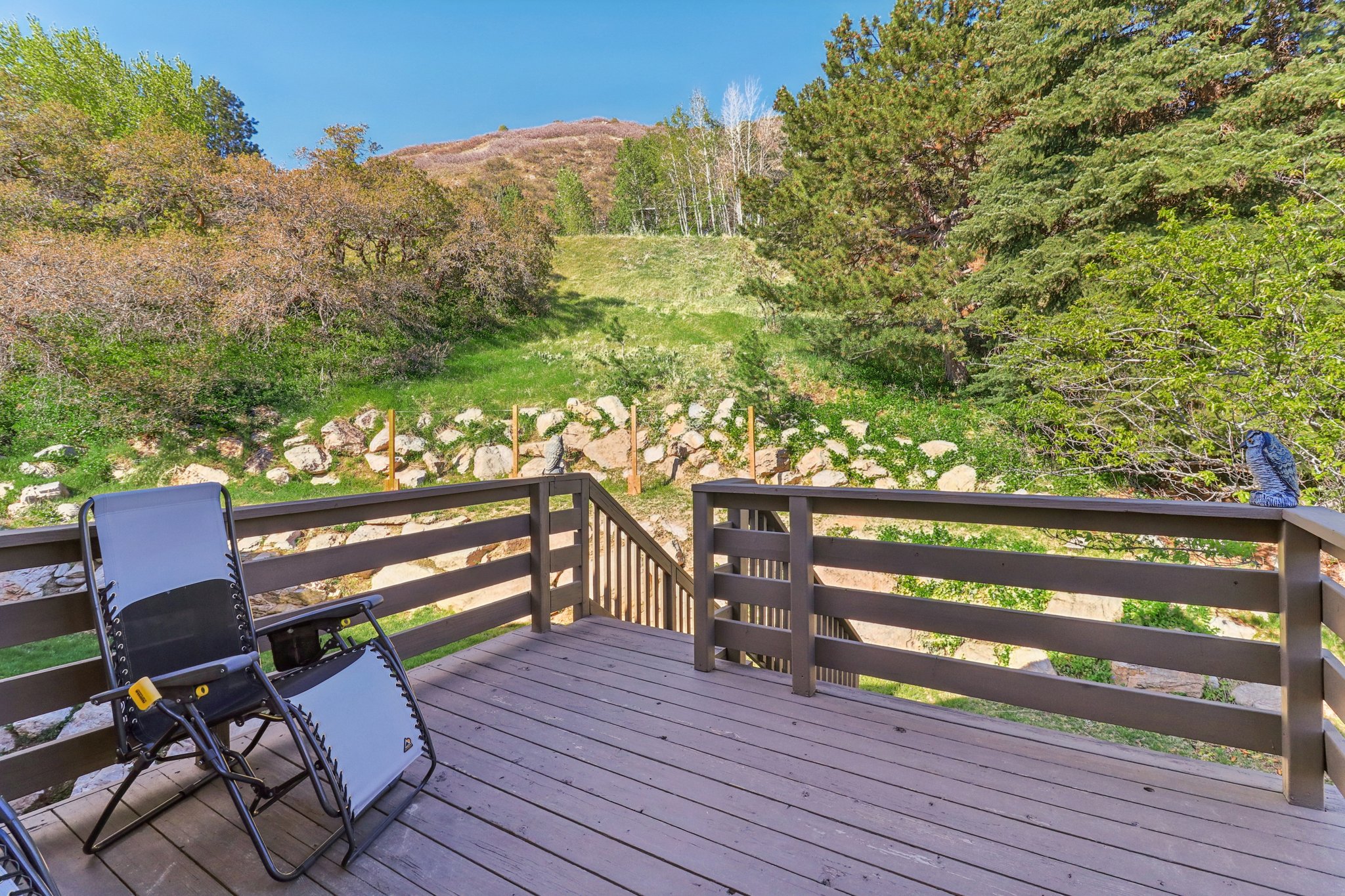 Spacious outdoor deck featuring wood-finish decking and dark wood railings