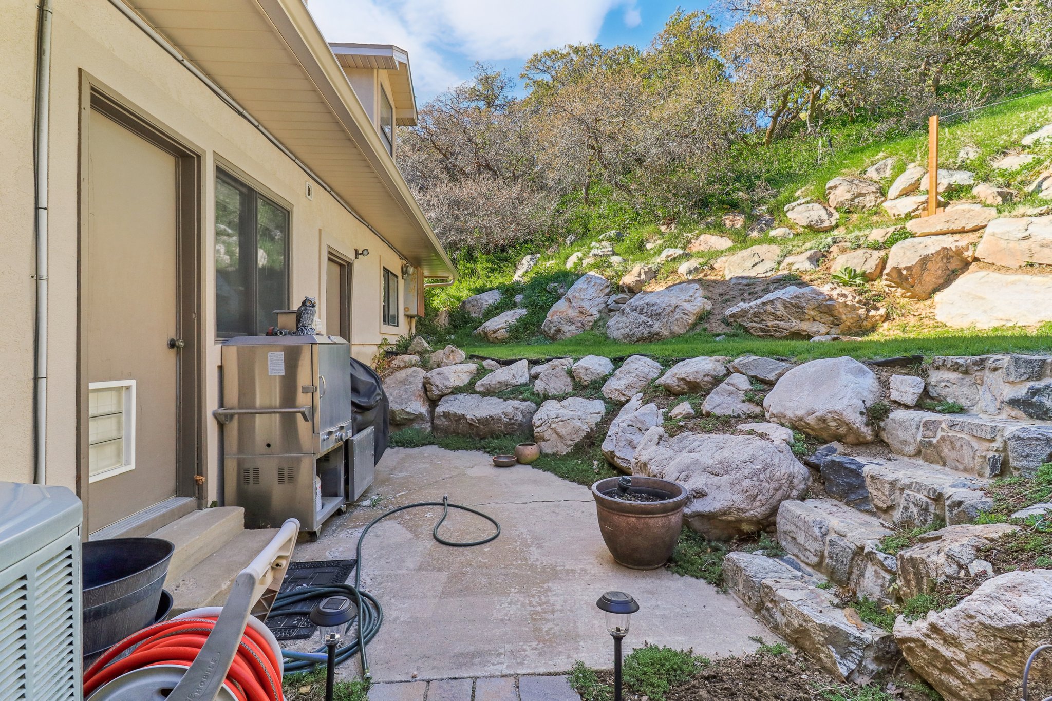 Rear patio with concrete slab and stacked stone retaining walls