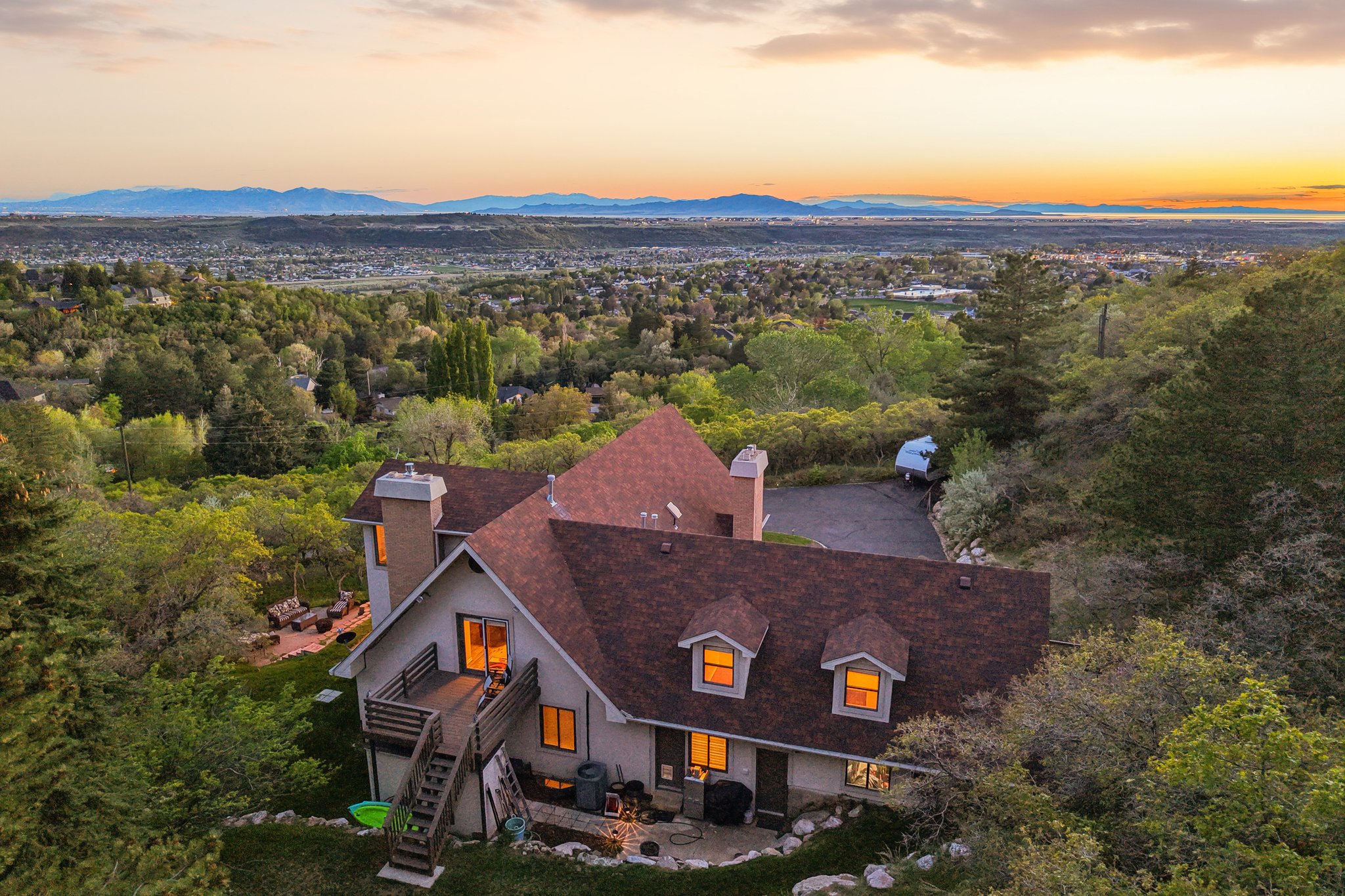 Multi-level residence with a wood deck and an expansive paved driveway