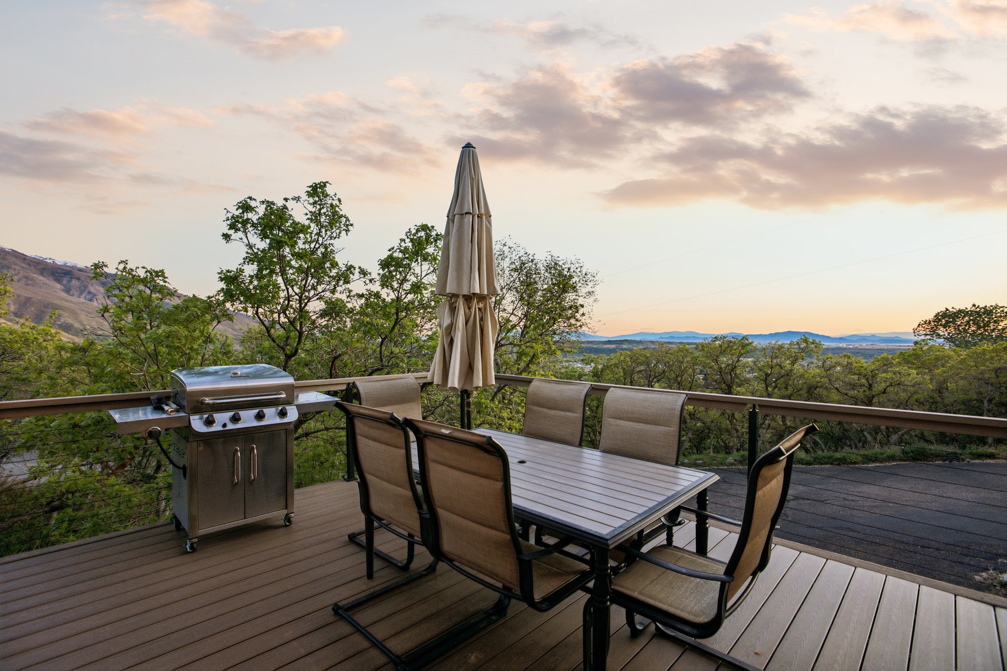 Spacious outdoor deck featuring wood-finish flooring, a full-length railing, and expansive mountain scenery