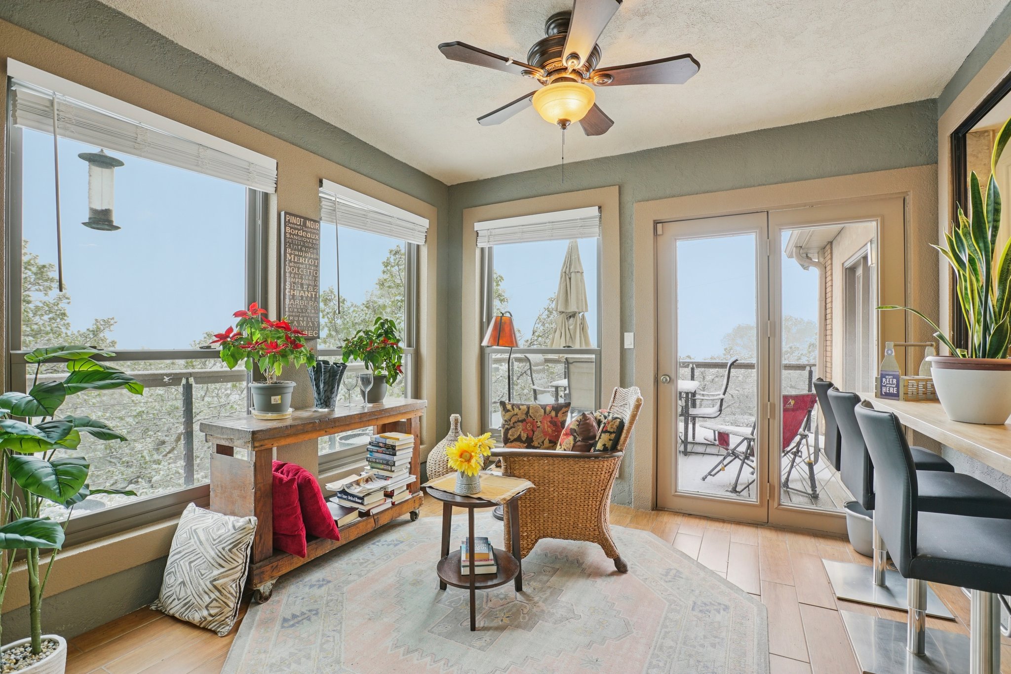 Sunroom featuring wood-finish flooring and a ceiling fan with light fixture