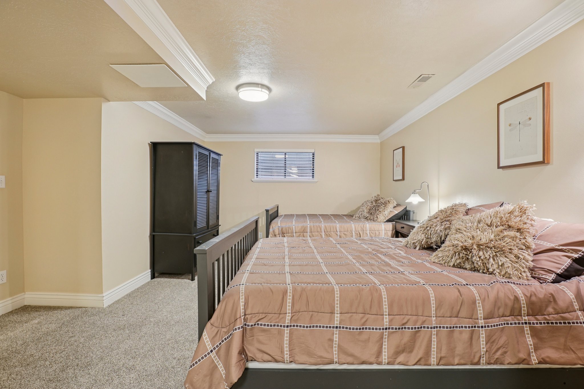 Plush carpet flooring complements neutral wall tones and white crown molding