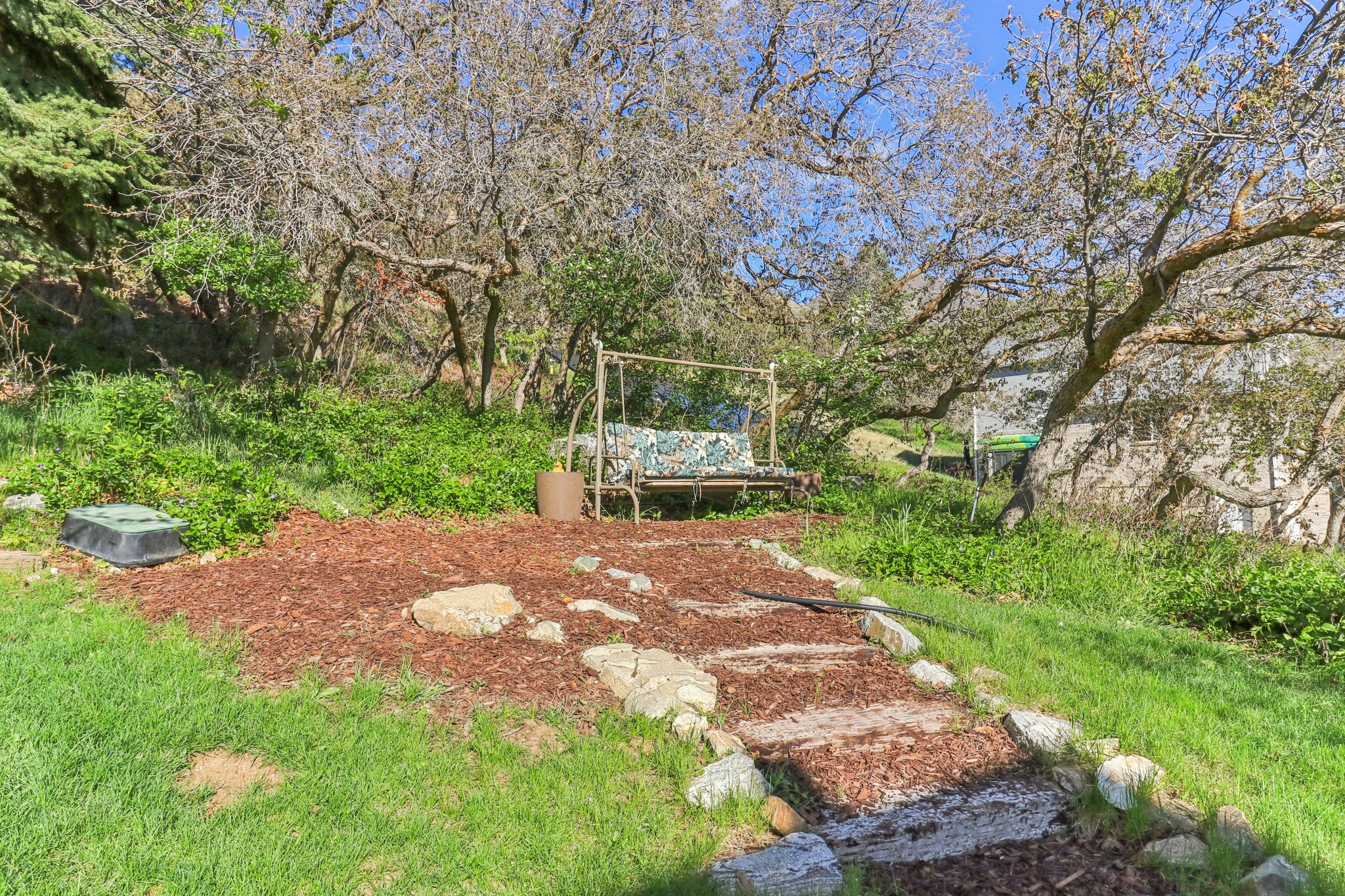 Terraced yard featuring a wood chip path with stone accents