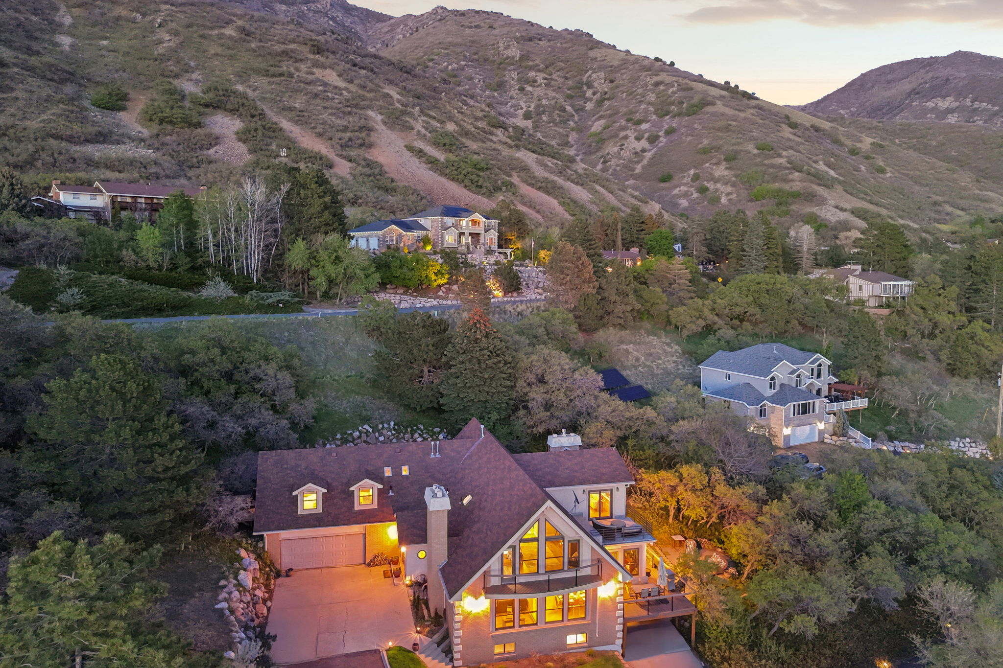 Hillside property featuring a multi-level structure with a prominent gabled roof and dormer windows