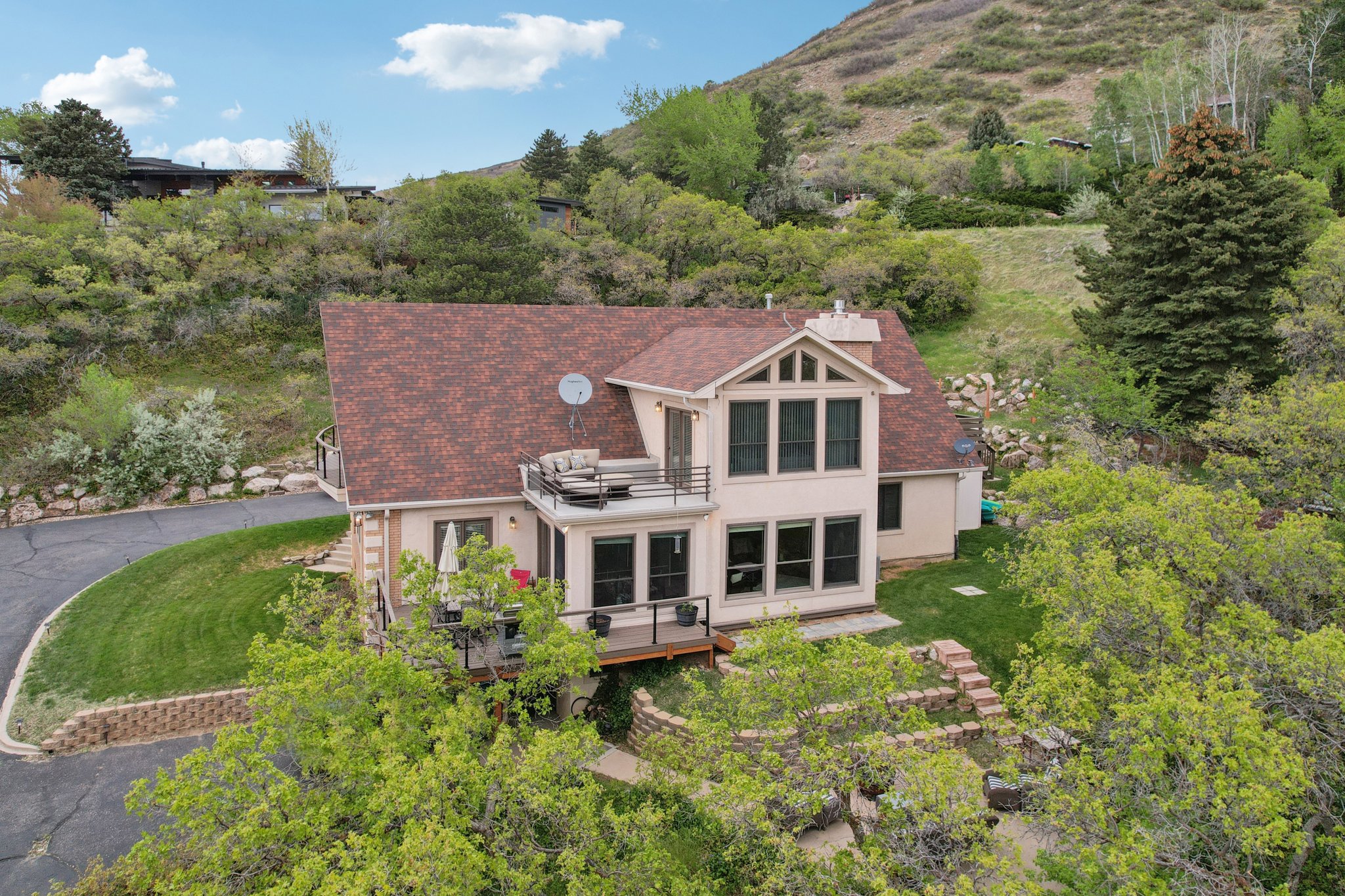Multi-level property featuring a brown shingle roof and light-colored siding