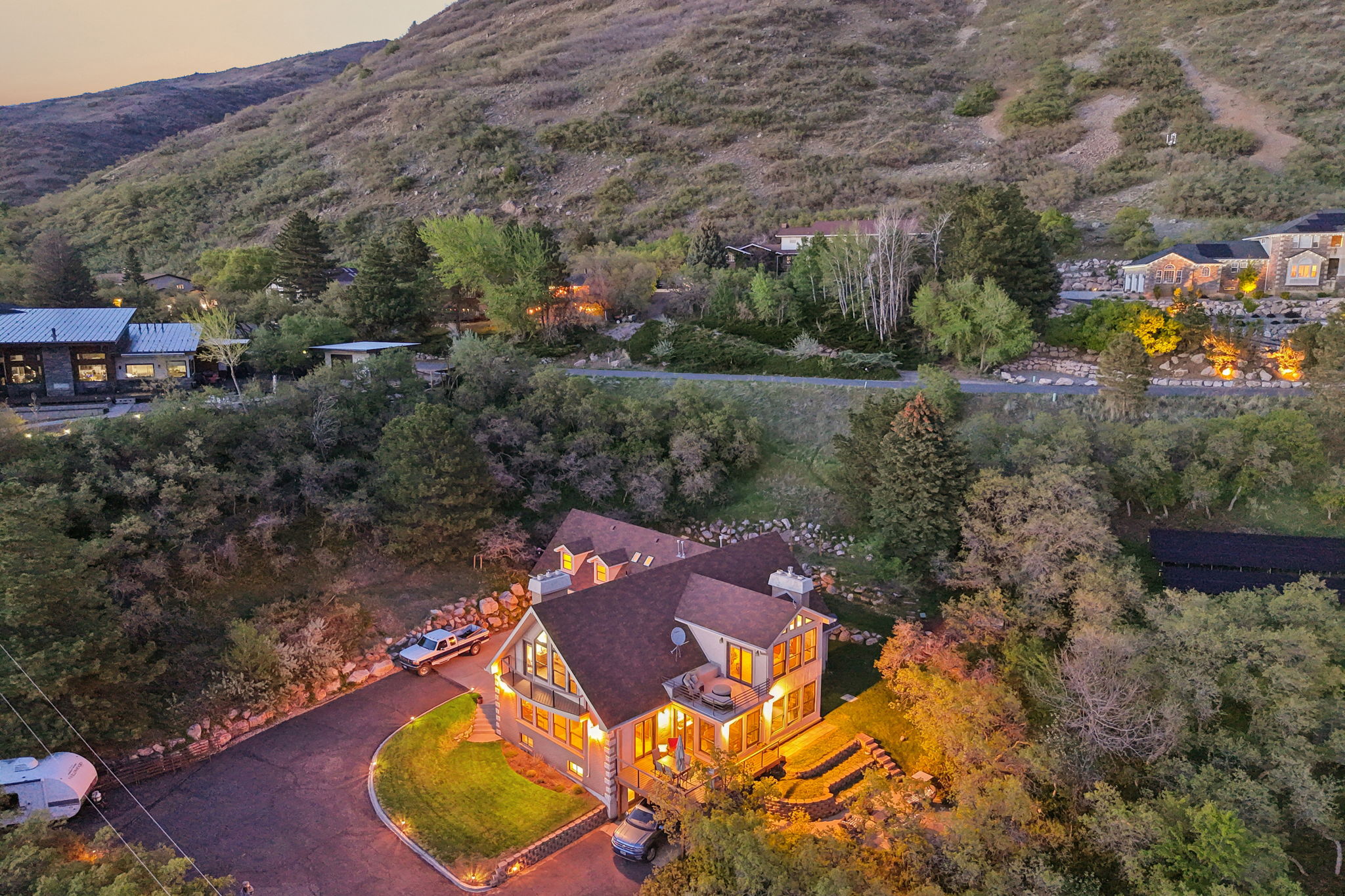 Contemporary residence featuring a peaked roofline, multiple windows, and a curved driveway