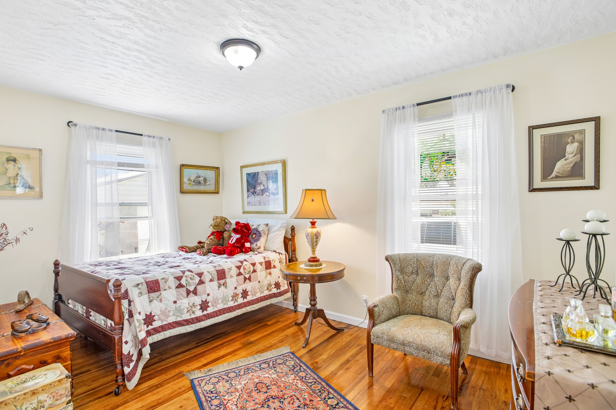 Hardwood flooring throughout featuring white walls and a textured ceiling