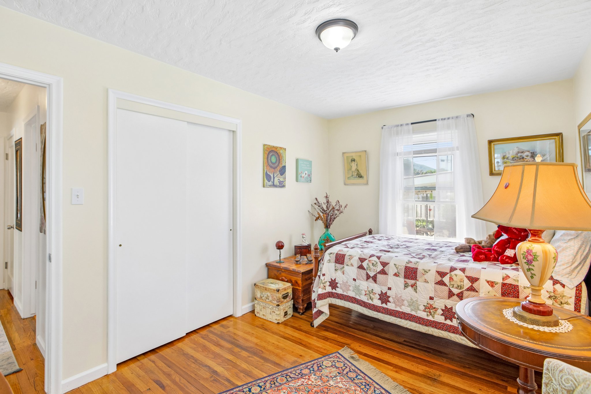 Interior room featuring wood-finish flooring, light-toned walls, and a window with natural light