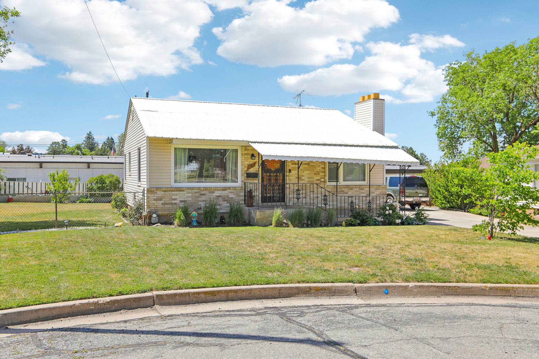 Single-story residence featuring a white metal roof and light-colored siding