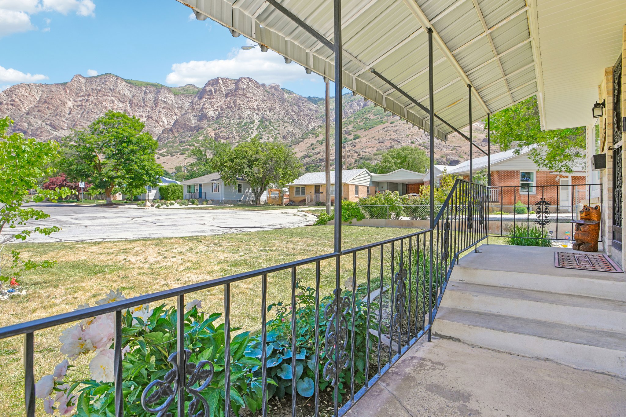 Covered front porch with a metal roof and decorative iron railing