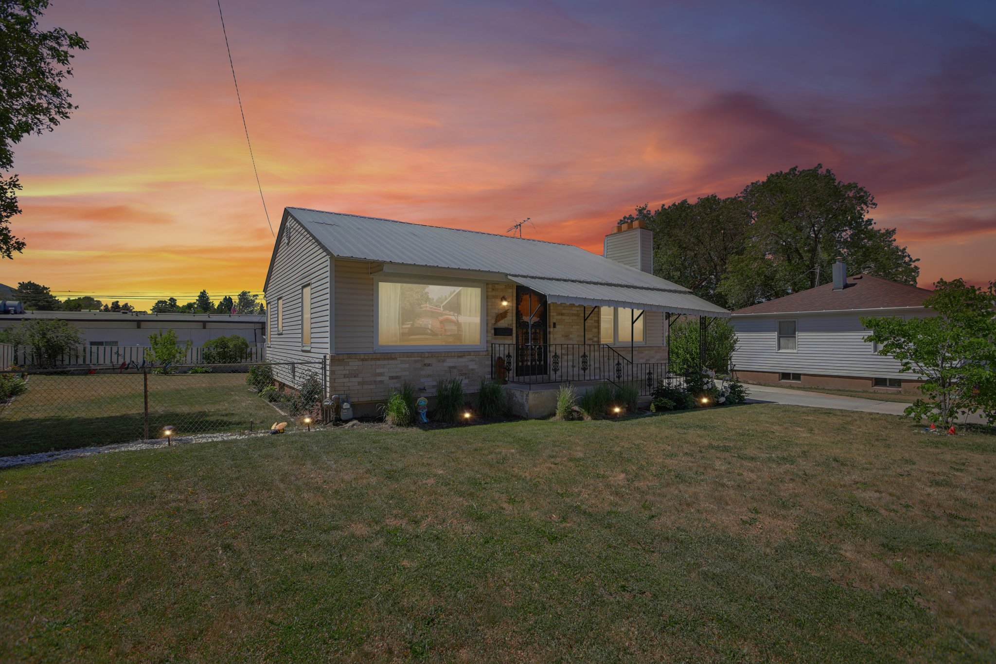 Ranch-style residence featuring a metal roof and light-colored siding