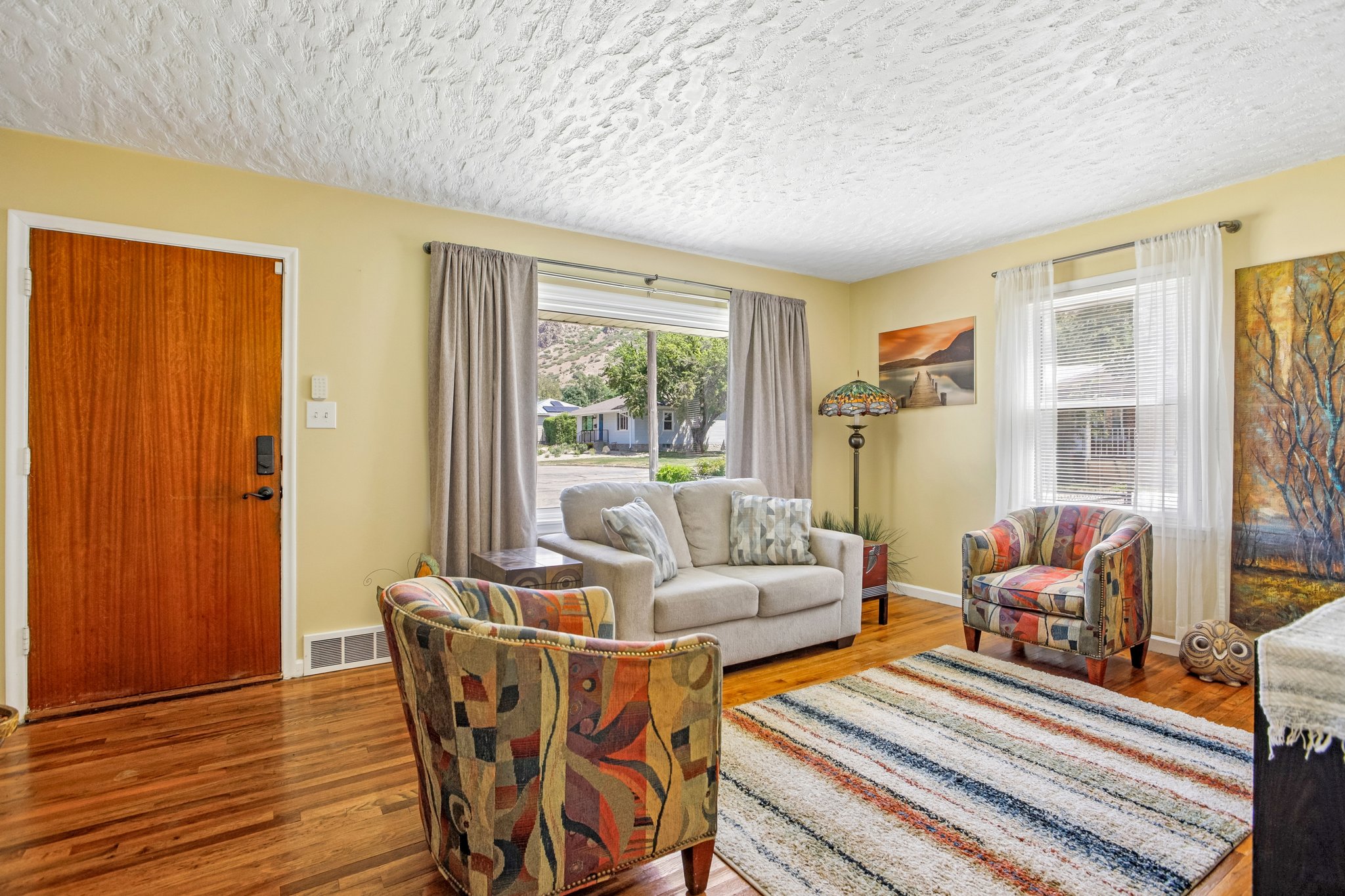 Warm wood-finish flooring complements the light-toned walls in this living space