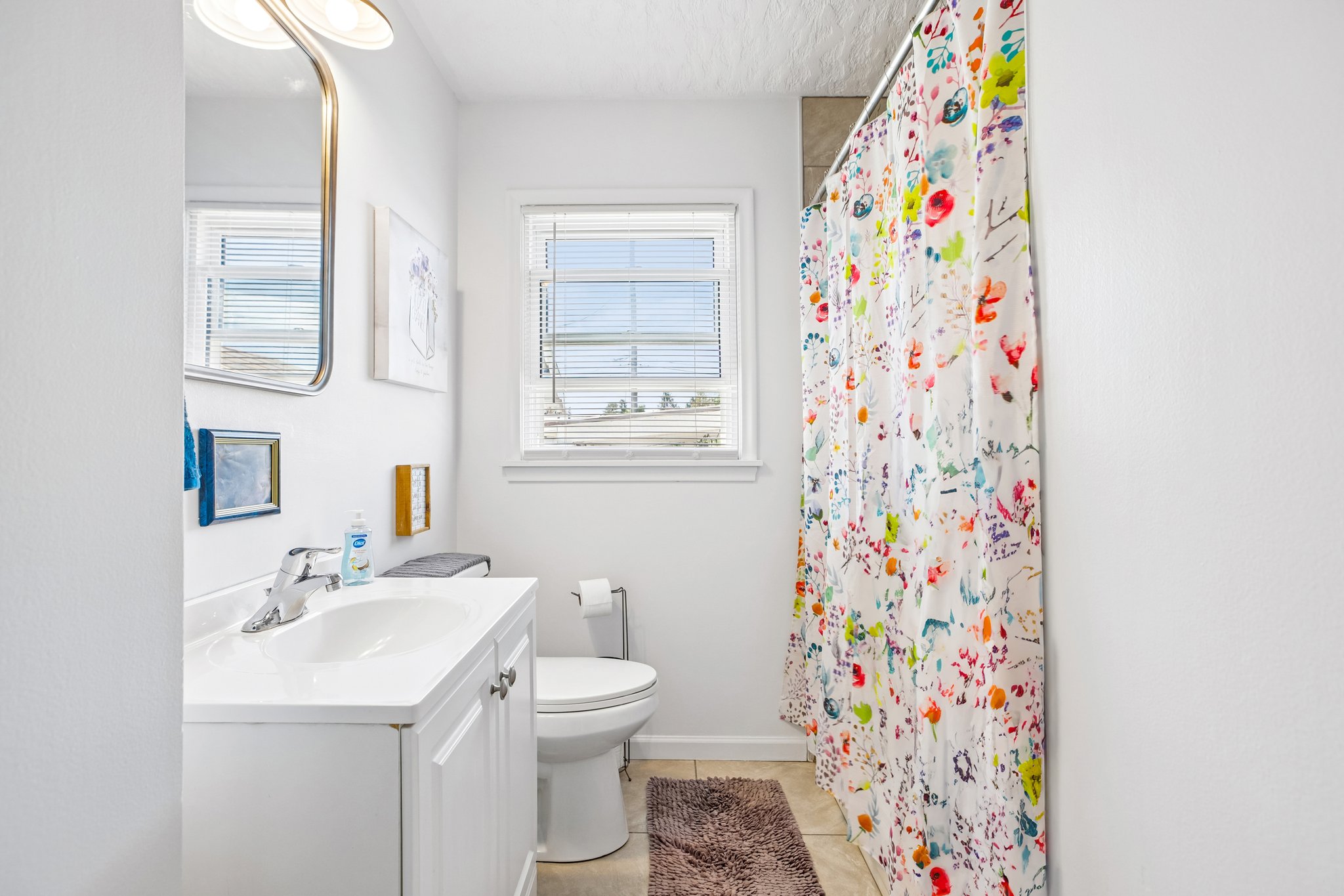 Bathroom featuring a single vanity with white cabinetry, a rectangular sink, and chrome fixtures