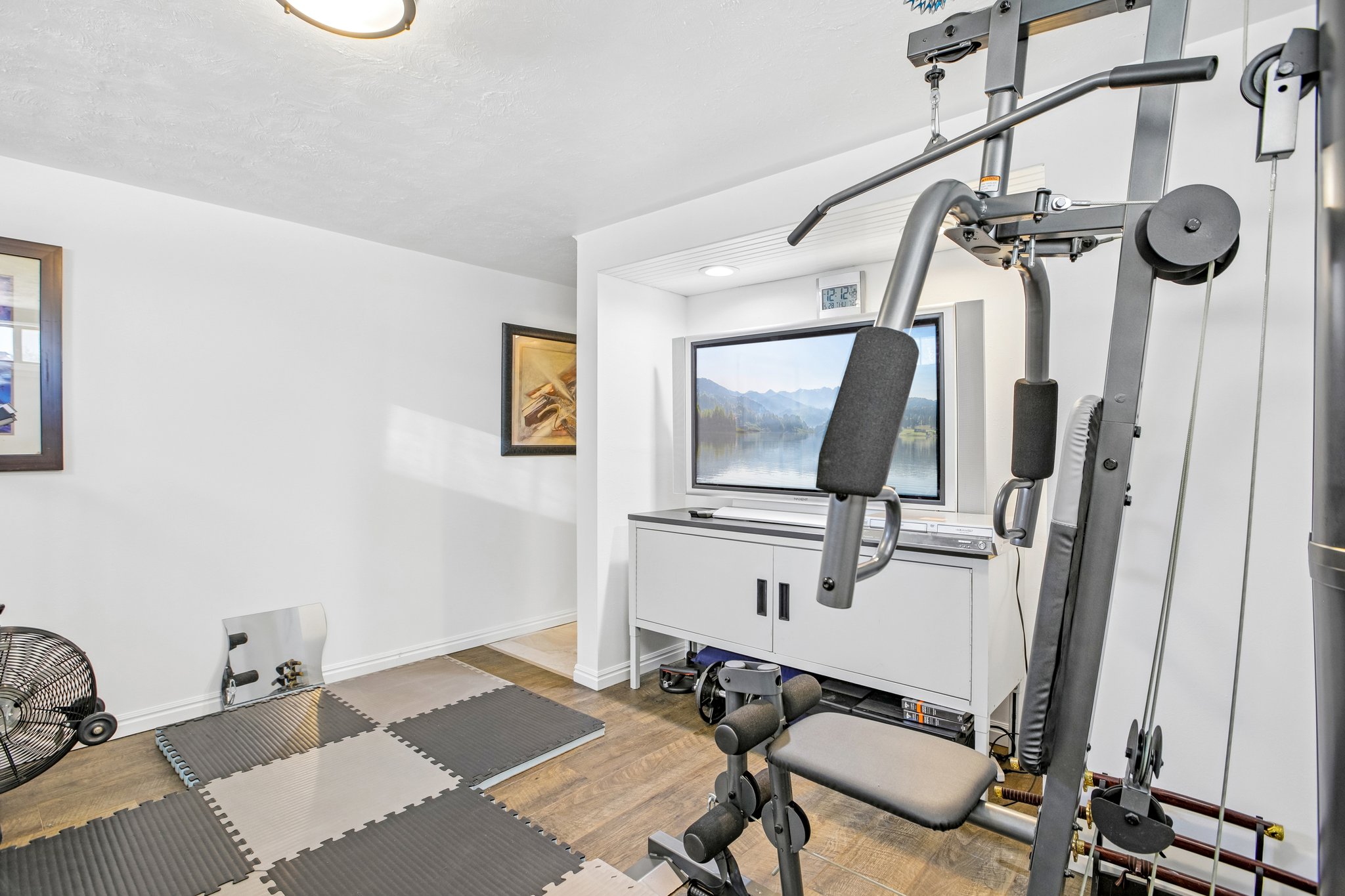 Dedicated room featuring wood-finish flooring and a built-in media console with cabinet storage