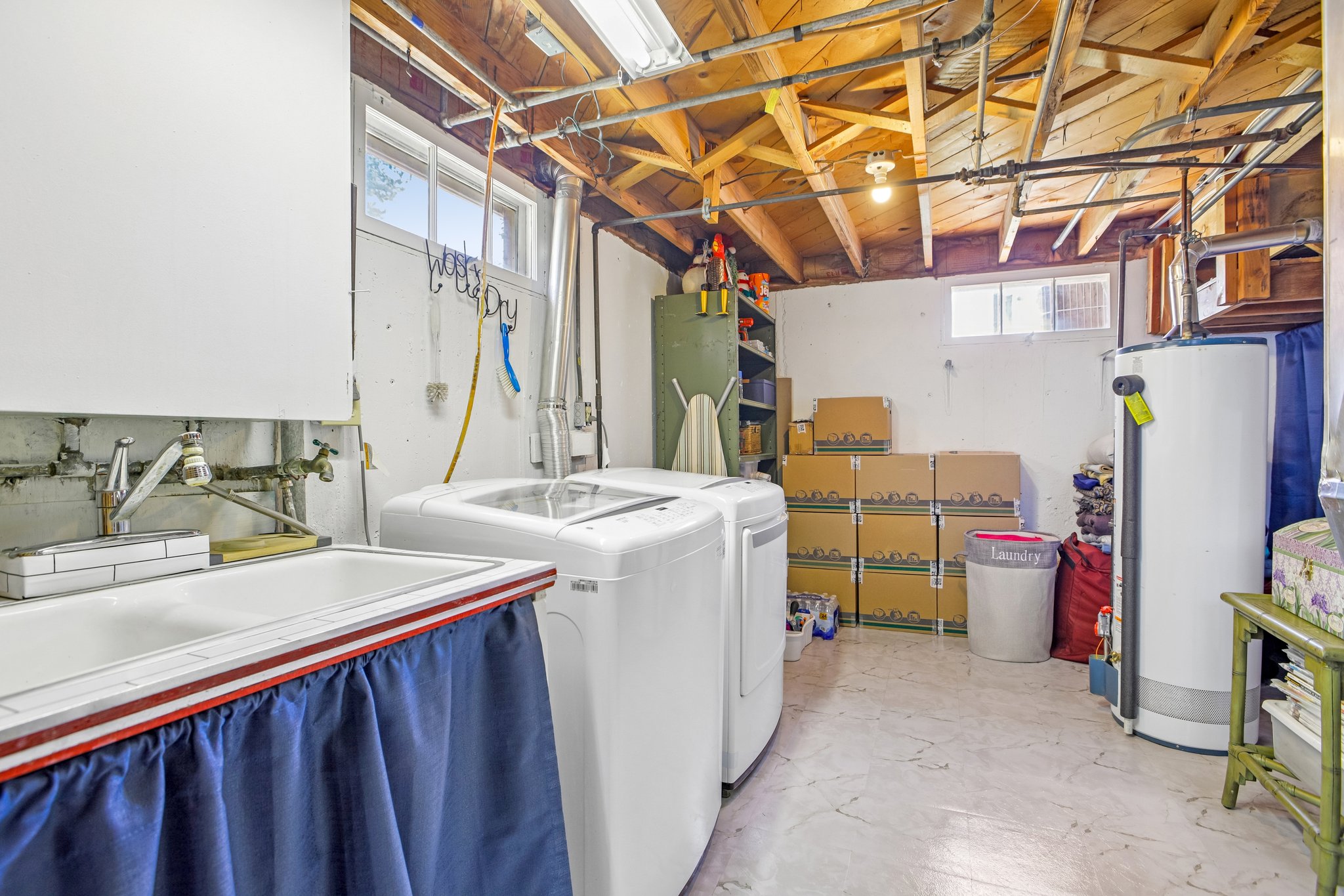 Utility room with exposed ceiling joists and plumbing