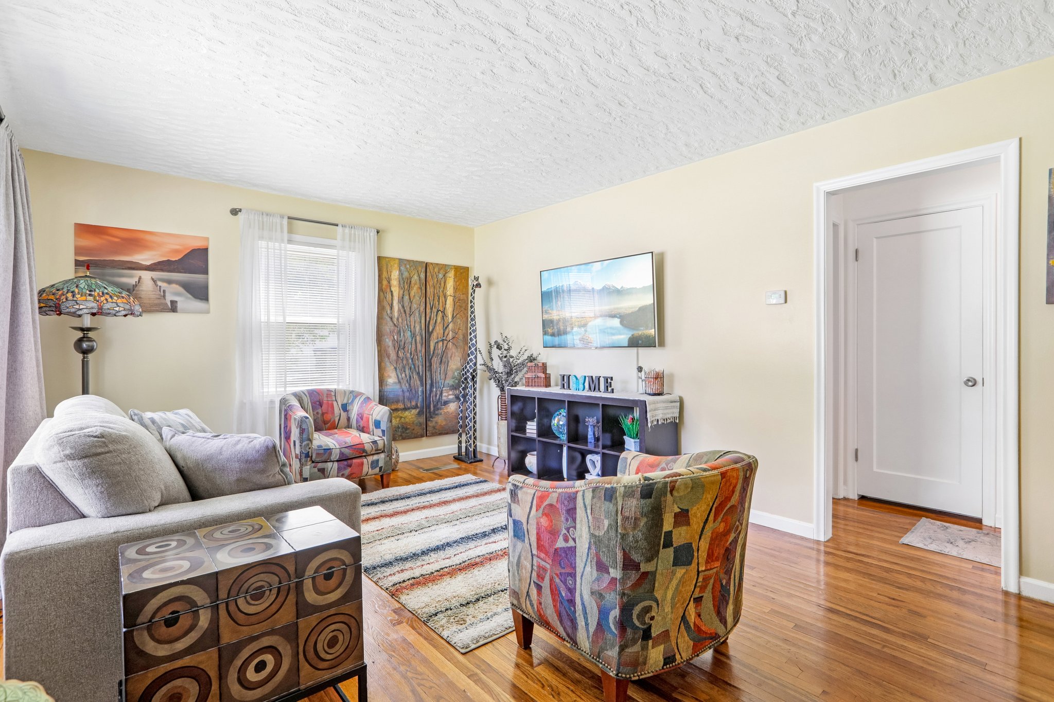 Inviting living area featuring wood-finish flooring, light-toned walls, and a textured ceiling