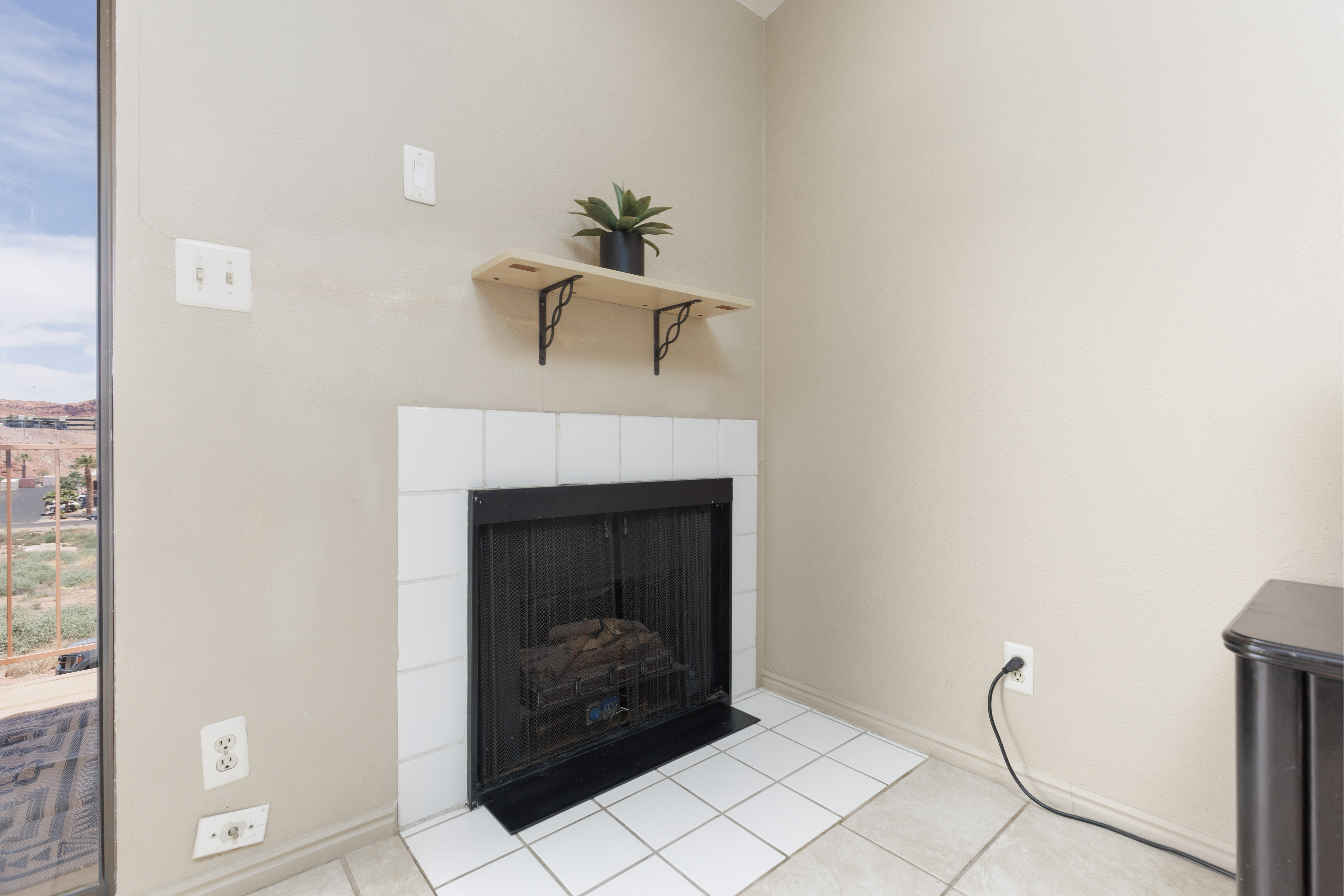 Fireplace featuring a white tile surround and hearth
