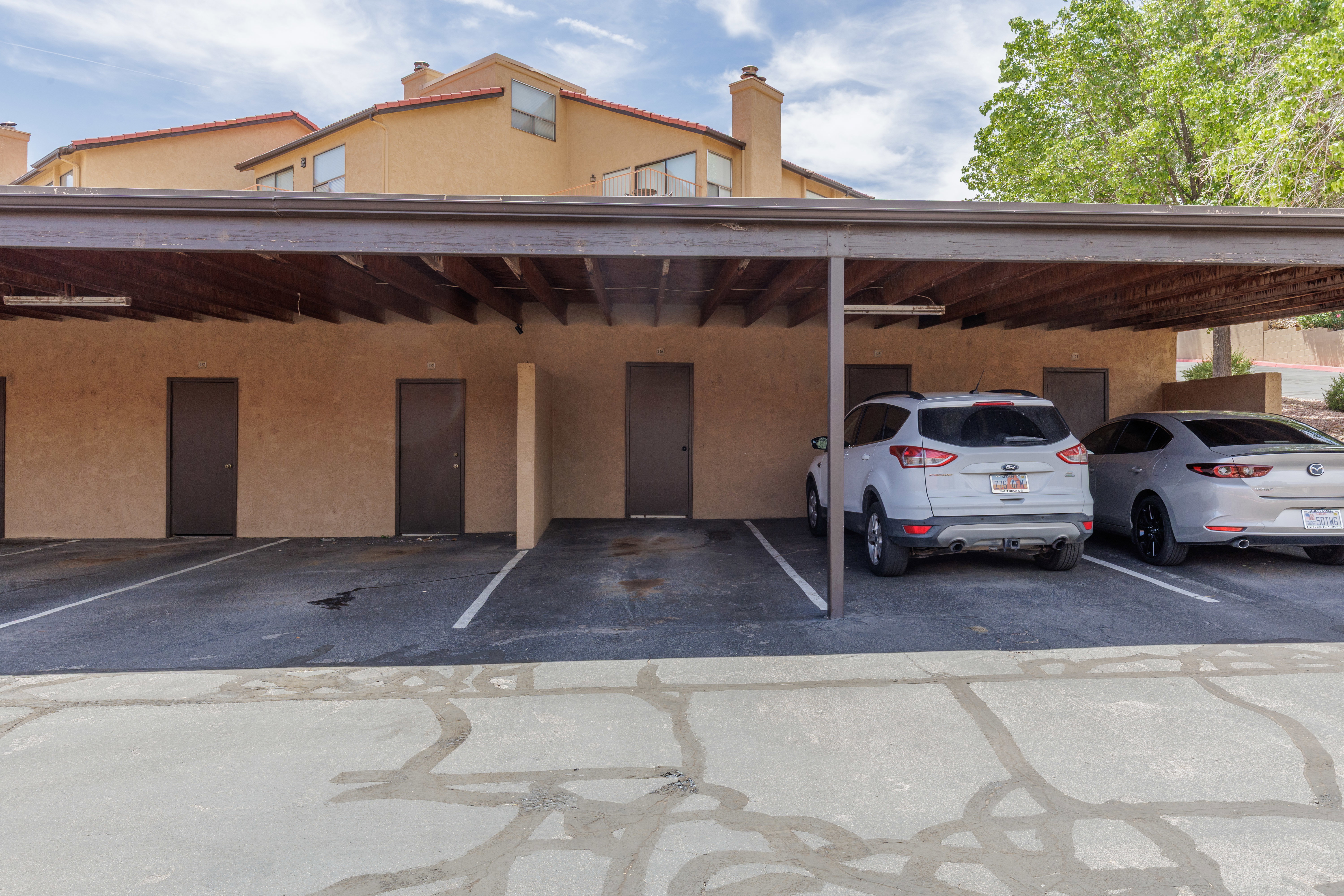 Carport parking structure featuring multiple parking spaces and integrated storage units