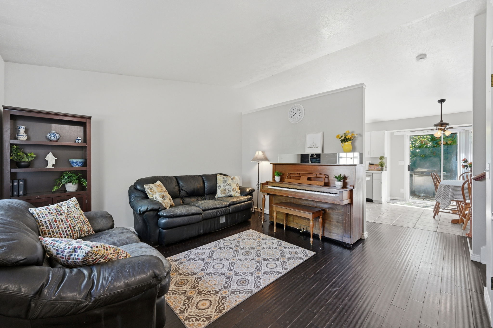 Living area featuring dark wood-finish flooring, light-toned walls, and a built-in partial wall