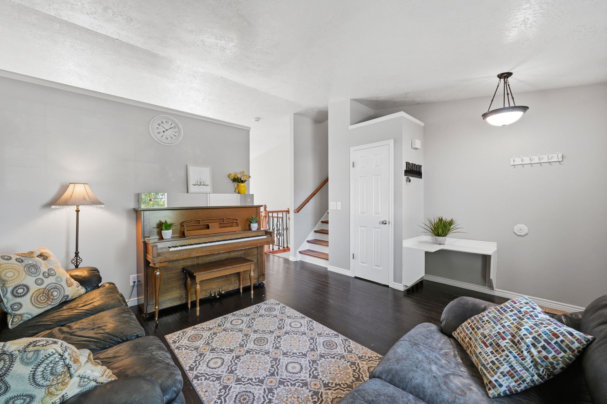 Spacious interior featuring dark wood-finish flooring, light grey wall paint, and white trim accents
