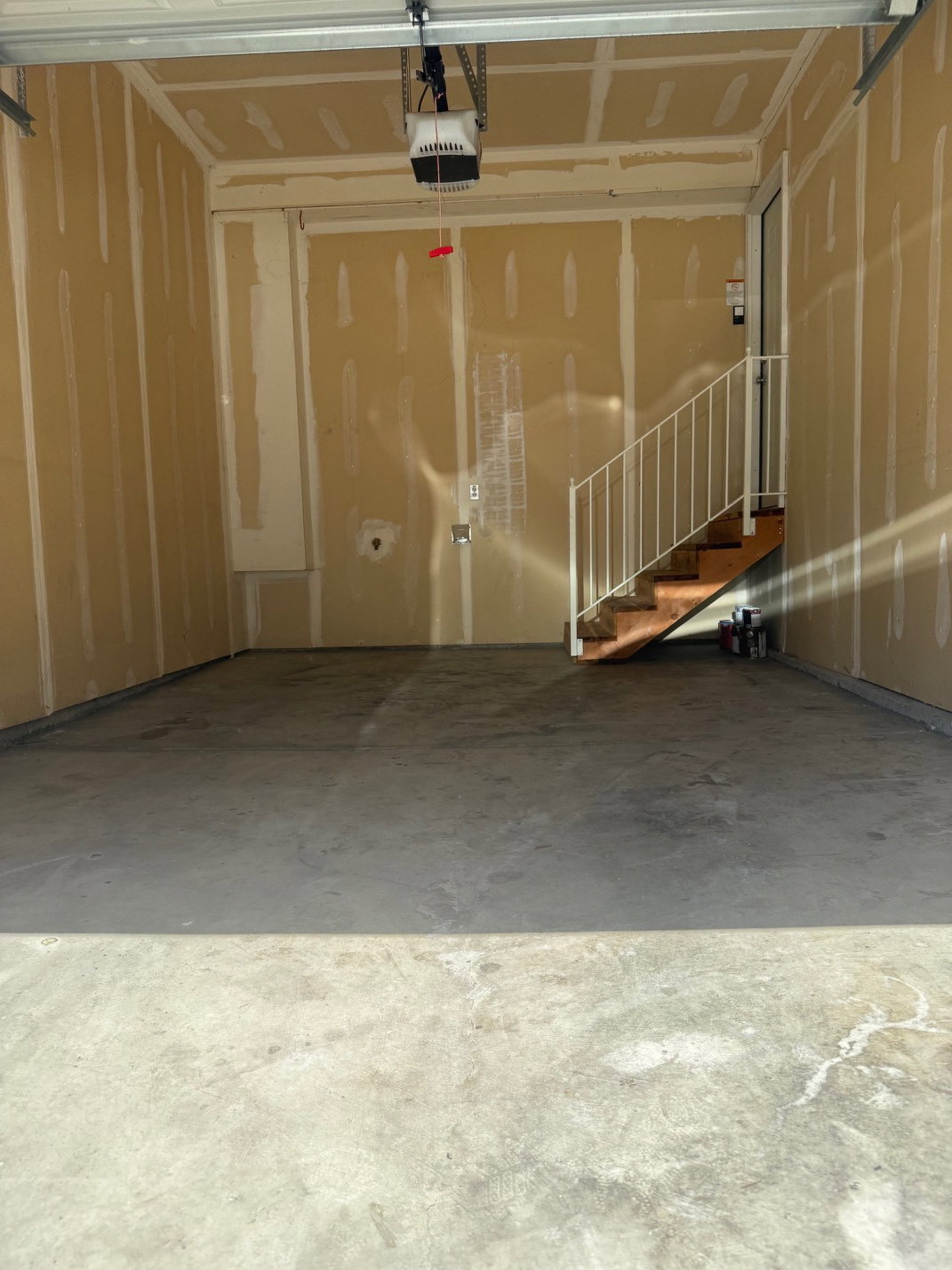 Spacious garage with an automatic door opener and unfinished walls