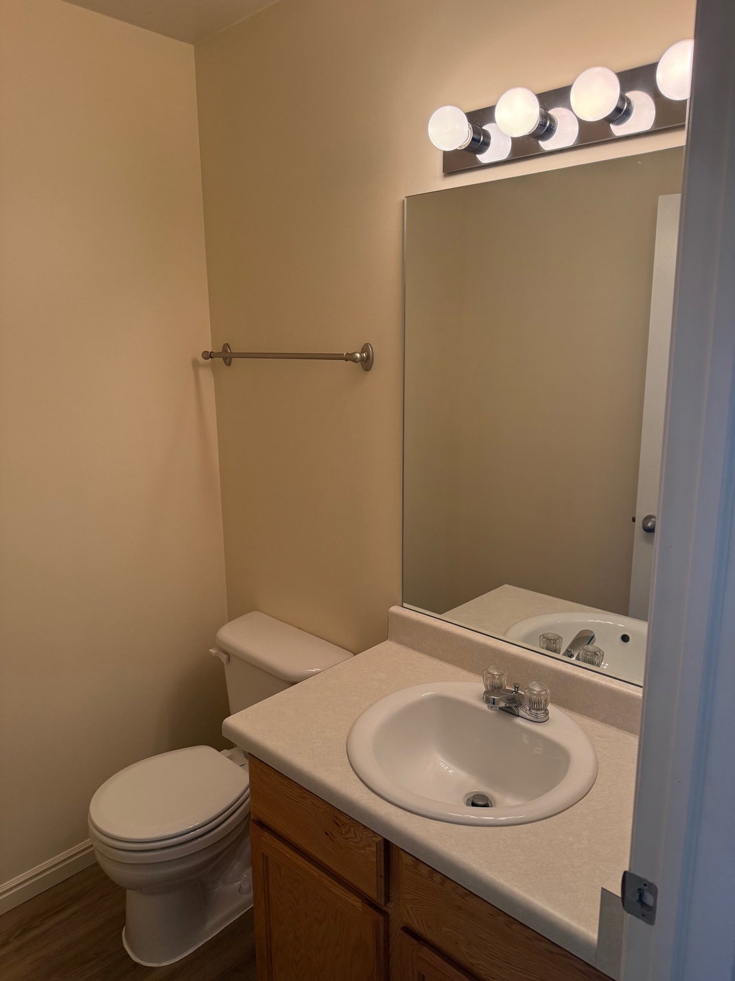 Half bathroom vanity with a laminate countertop, integrated sink, and wood-finish cabinetry