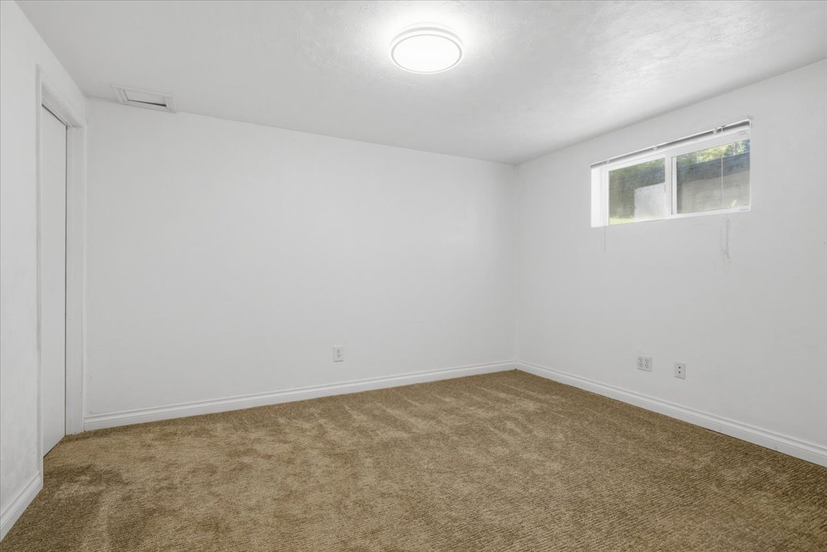 Neutral wall palette with a single window and recessed ceiling light