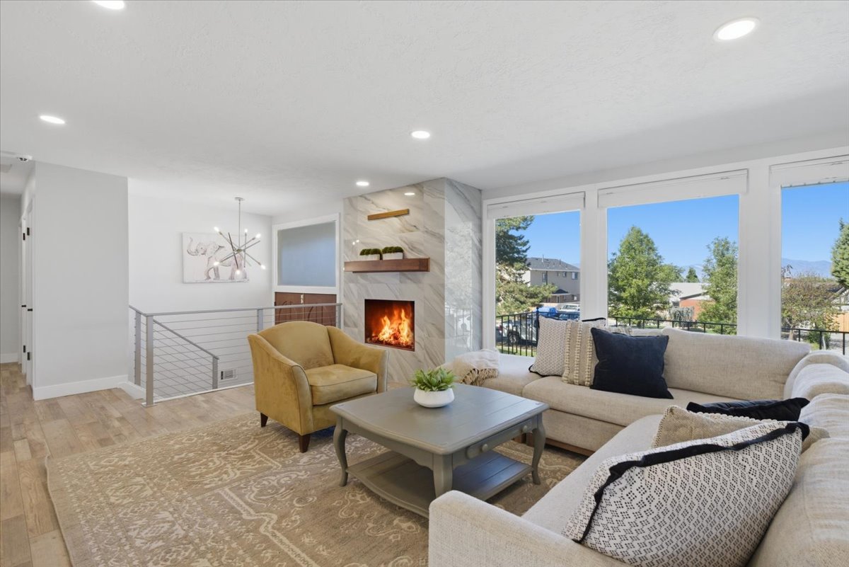 Living area featuring a modern linear fireplace with a marble-finish surround and a built-in wood mantel