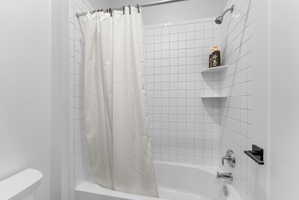 Bathtub and shower combination featuring white subway tile surround