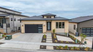 Contemporary exterior with a dark-pitched roof and light-colored stucco and stone veneer