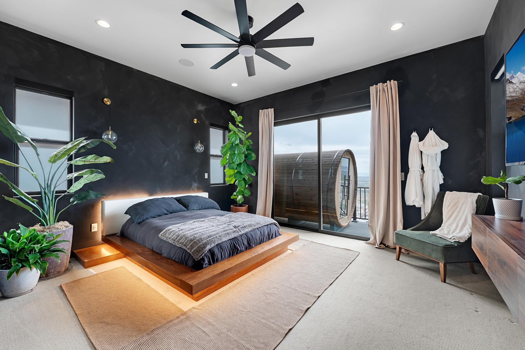 Spacious bedroom featuring dark accent walls, a contemporary ceiling fan, and recessed lighting