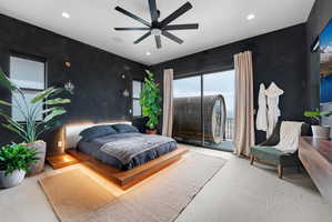 Spacious bedroom featuring dark accent walls, a contemporary ceiling fan, and recessed lighting