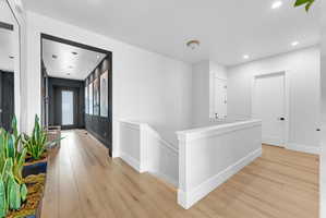 Light wood-finish flooring throughout the upper hallway and entryway