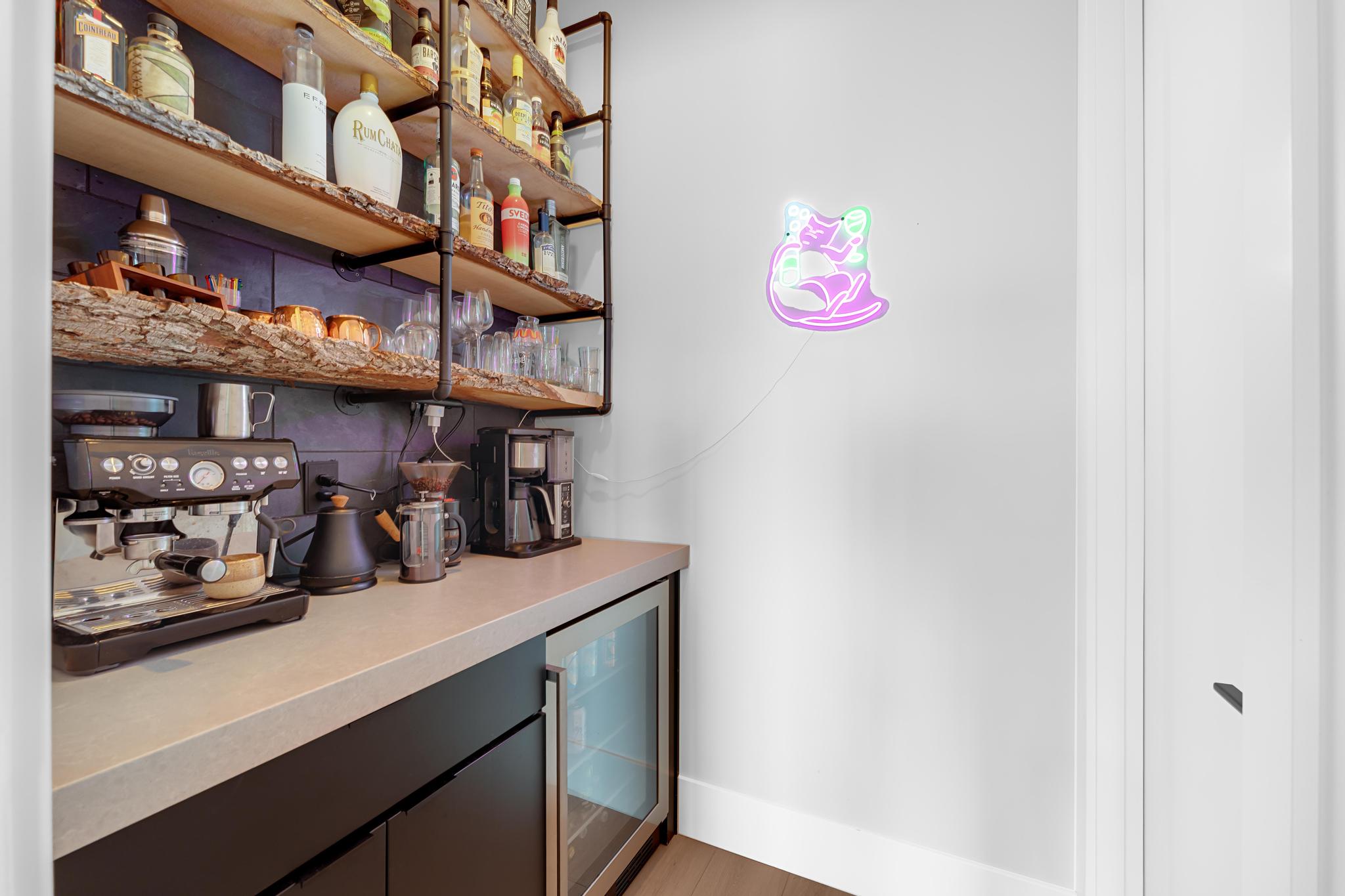 Custom beverage station featuring a built-in under-counter refrigerator, open shelving with live-edge wood, and matte black cabinetry