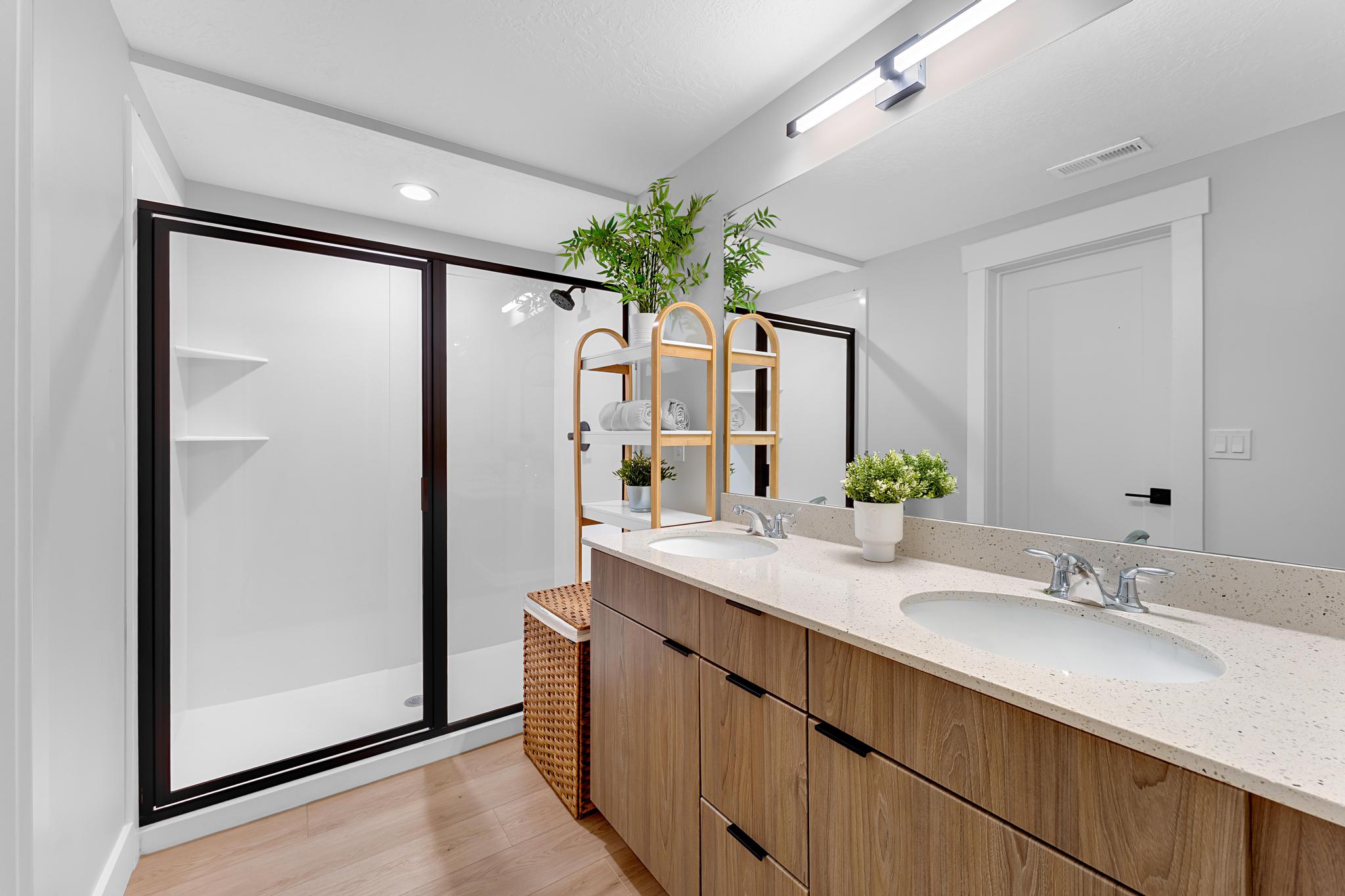 Bathroom featuring a dual vanity with light-toned wood-finish cabinetry and a speckled countertop