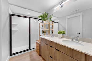 Bathroom featuring a dual vanity with light-toned wood-finish cabinetry and a speckled countertop