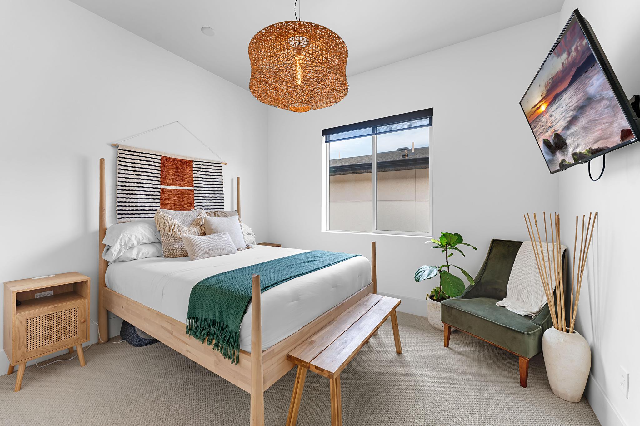 Bedroom featuring light-colored carpeting and a window with a roller shade