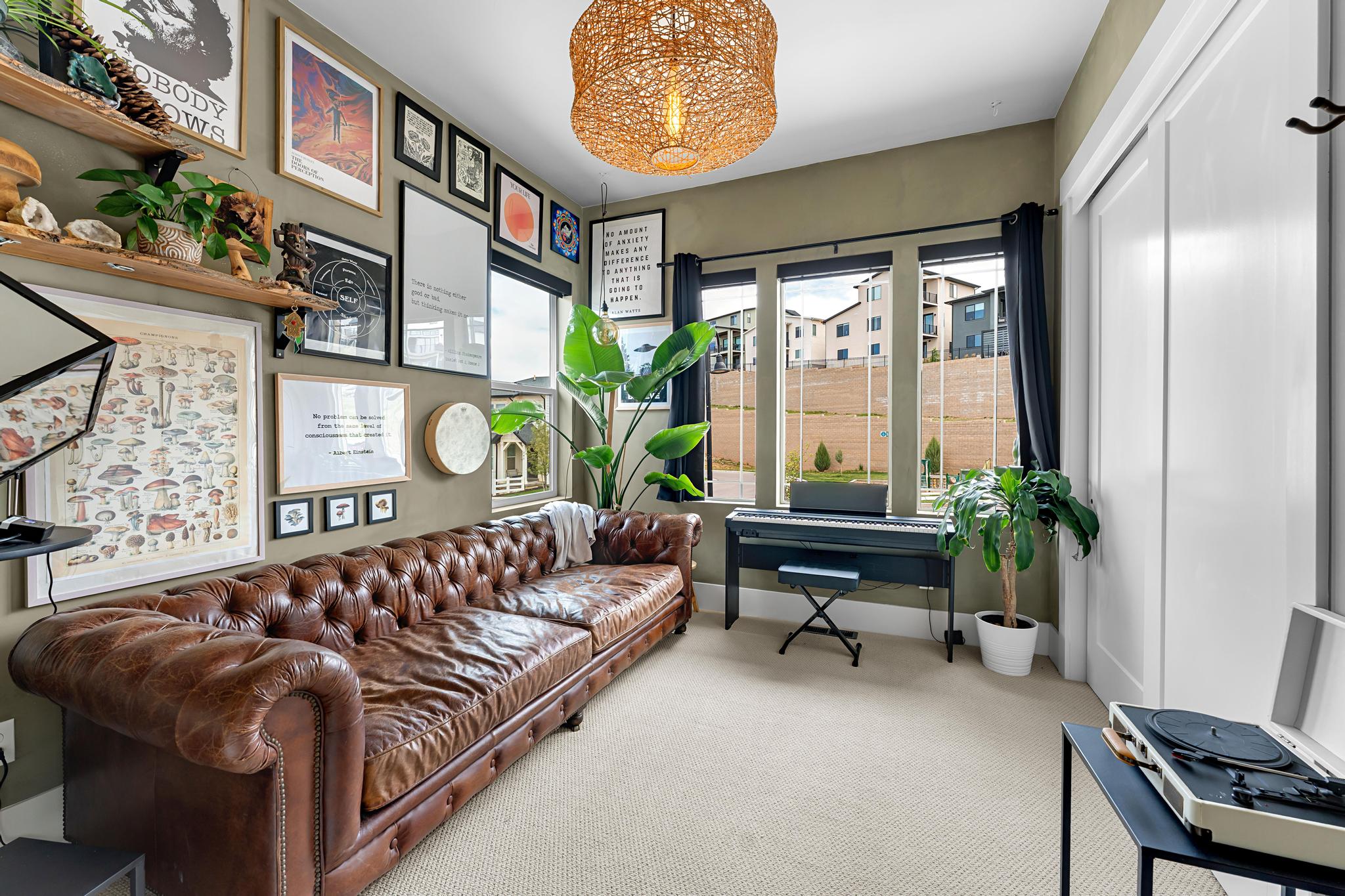 Carpeted interior space featuring a wall of framed art and shelving