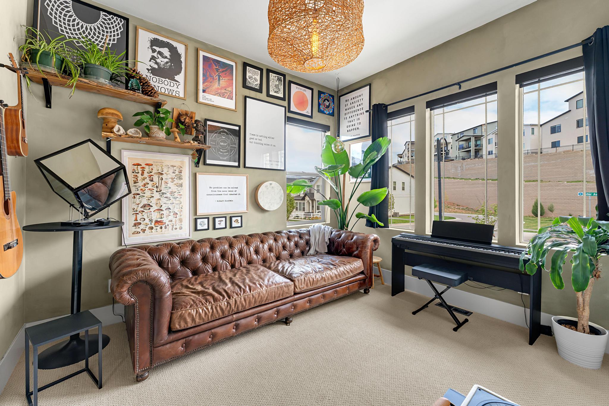 Spacious room featuring multiple large windows, wall-mounted shelving, and a natural fiber pendant light fixture